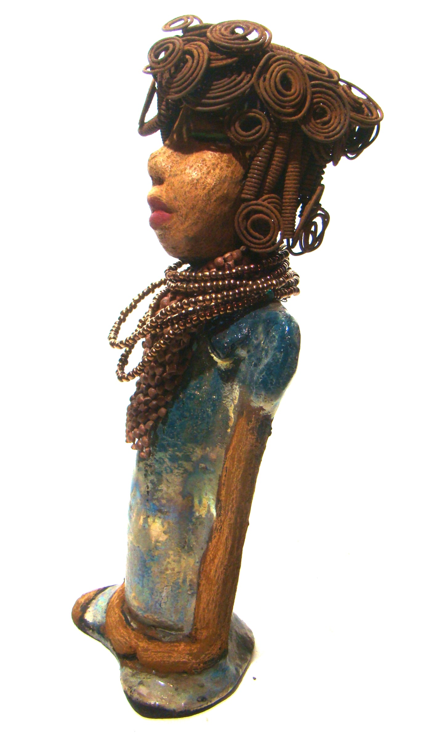 Sherri stands 13' x 4" x 2.5" and weighs 3.05 lbs. She has over 25 feet of wire curls and coils. Sherri has a sweet honey brown complexion. Her dress is a metallic multi colored green with an amber beaded necklace and scarf. Sherri has the familiar long loving arms at her side.