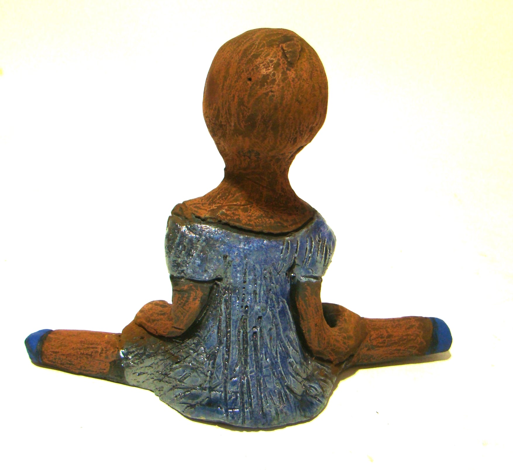 Vida sits 5" x 6" x 3" and weighs 10 ozs.     She is in a comfortable yoga pose.     Vida has a lovely honey brown complexion without hair.     Vida has a textured light blue with matching blue shoes.
