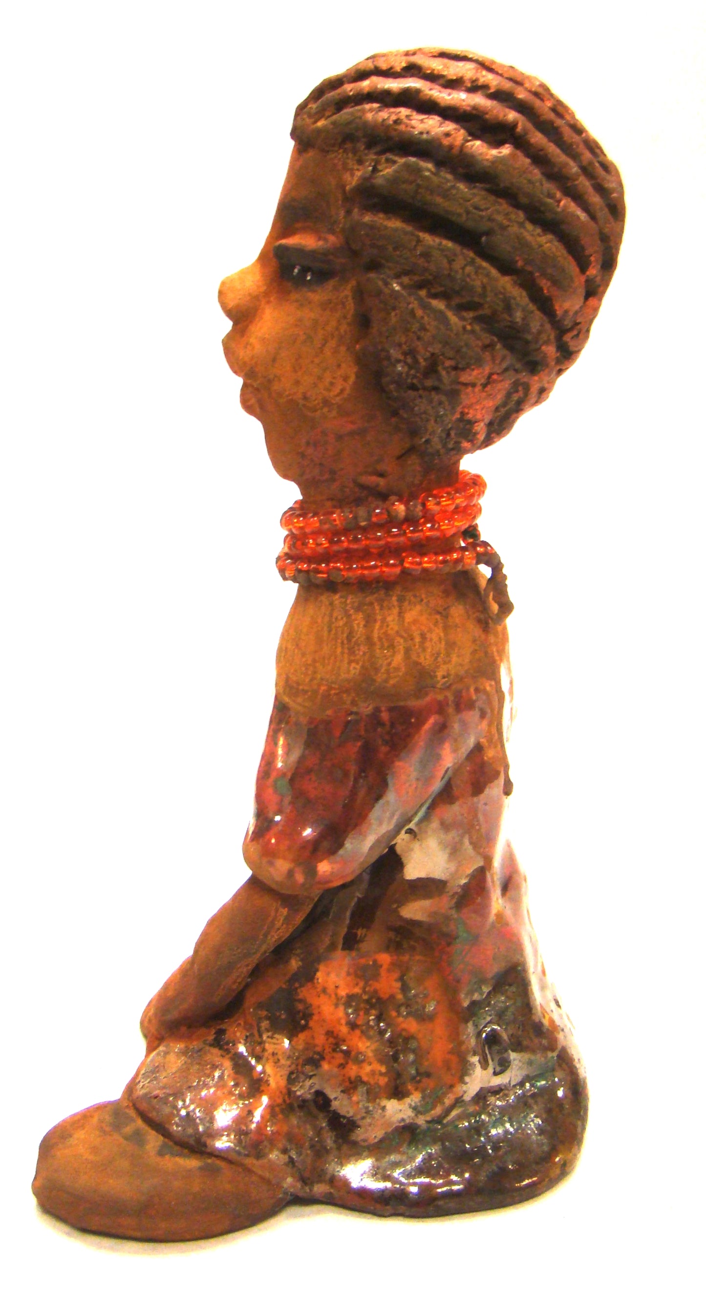 Meet Devonte! Devonte stands 8" x 6" x 4" and weighs 1.06 lbs. Devonte has a awesome honey brown complexion. She has braided clay hair. Devonte has long loving arms. She wears a metallic copper dress with red orange beads. Give Devonte a special place in your home!