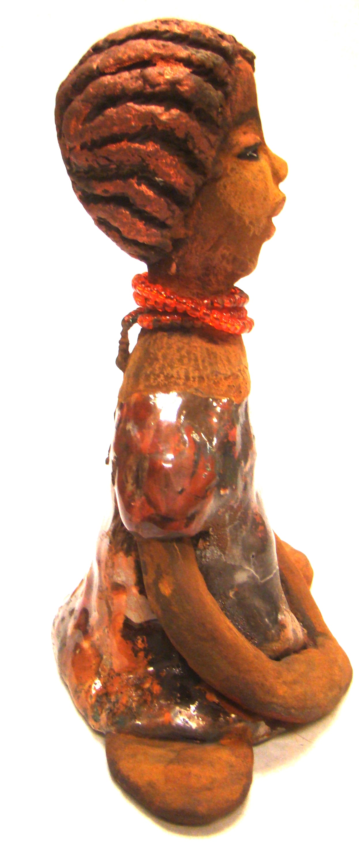 Meet Devonte! Devonte stands 8" x 6" x 4" and weighs 1.06 lbs. Devonte has a awesome honey brown complexion. She has braided clay hair. Devonte has long loving arms. She wears a metallic copper dress with red orange beads. Give Devonte a special place in your home!