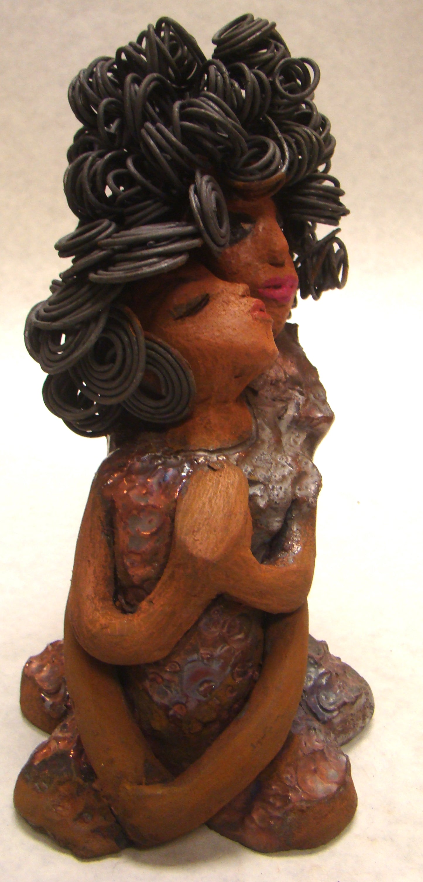 I Love You More stands 8.5 " x 4.5" x 4".5" and weighs 2.10 lbs. They have lovely honey brown complexions. Combined, I Love You More has over 25 feet of curly wire hair. They have glossy metallic copper dresses. They have long loving arms. One is embracing the other. I Love You More! will help illustrate the love that is in your home! Free Shipping!