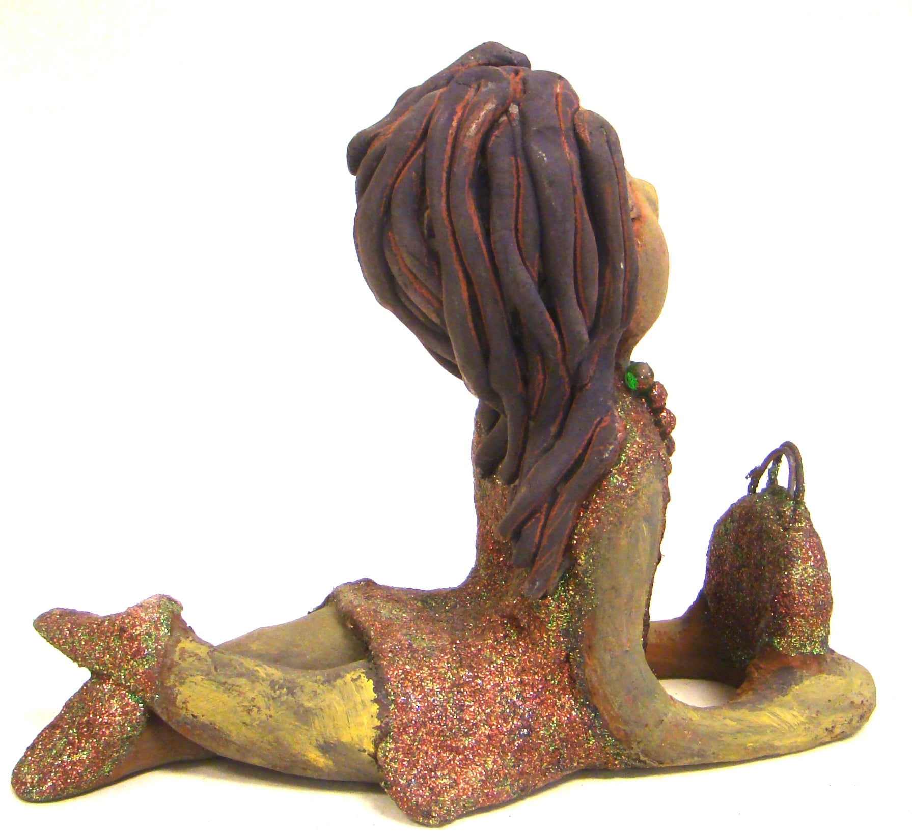 Lacey stands 6" x 3" x 7.5" and weighs 1.08 lbs. She has a lovely beige olive green complexions with ruby red lips. Her hair is made of coiled clay. Lacey is holding her handbag which matches her copper glittered dress. Give Lacey a special place in your home.