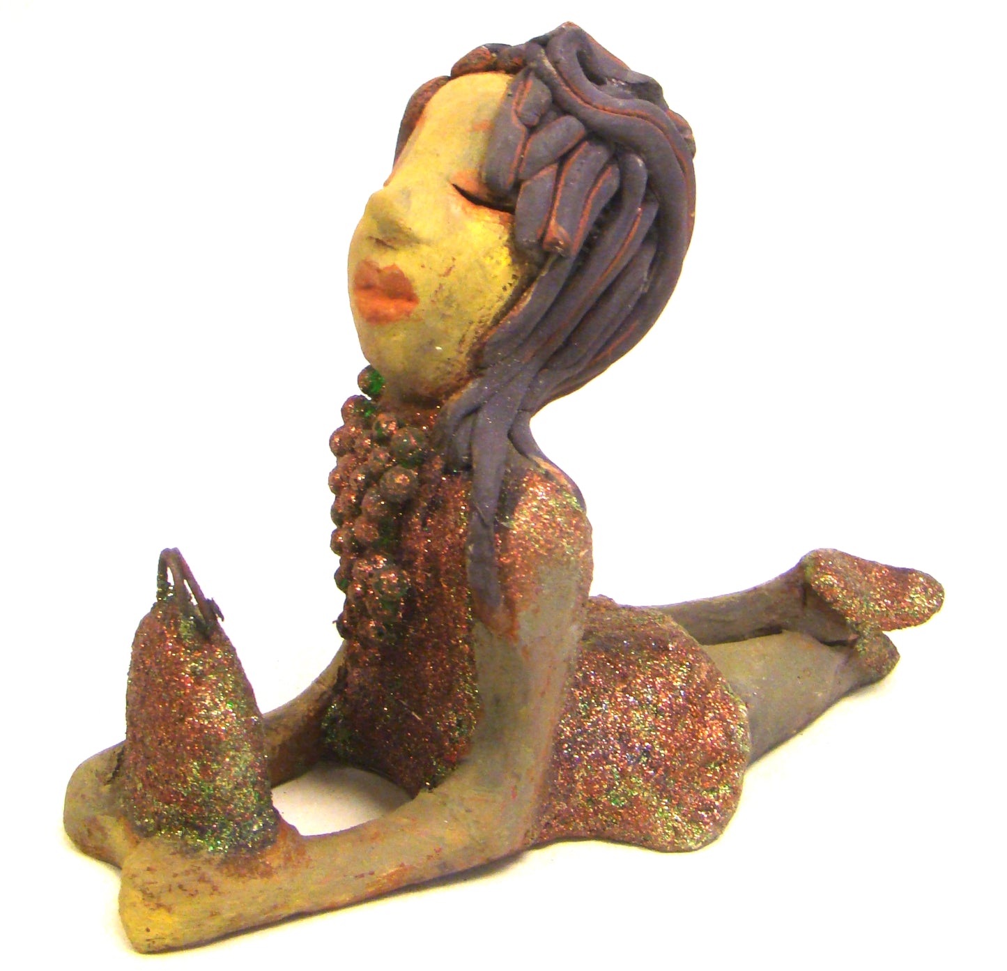 Lacey stands 6" x 3" x 7.5" and weighs 1.08 lbs. She has a lovely beige olive green complexions with ruby red lips. Her hair is made of coiled clay. Lacey is holding her handbag which matches her copper glittered dress. Give Lacey a special place in your home.
