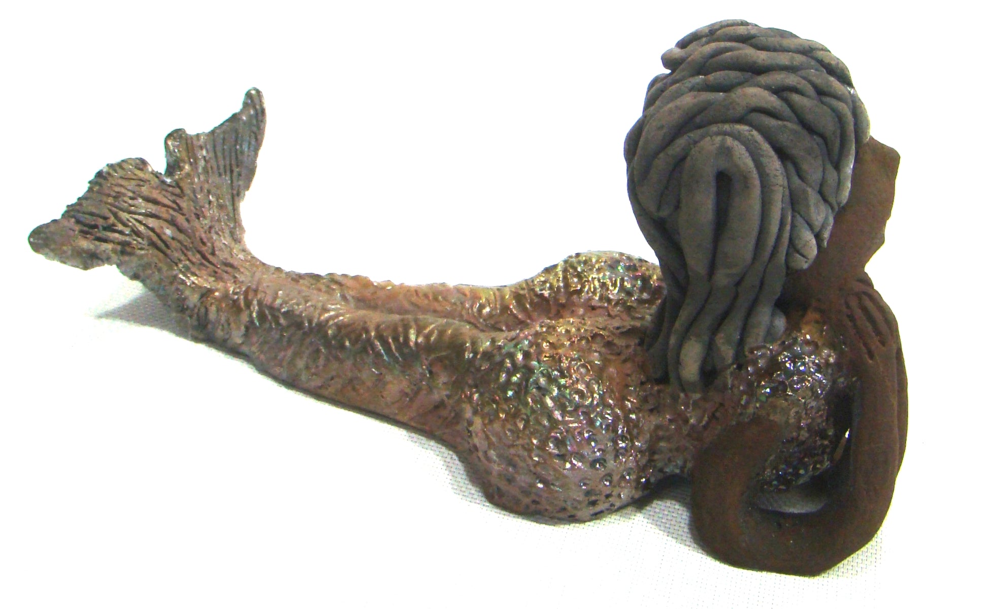 Meet Belinda!      Belinda is a voluptuous mermaid.     She stands 6.5" X 5" 9.5" and weighs 2.04 lbs.     Belinda has a dark chocolate complexion.     She wears a  dark smokey clay hairstyle.     She wears a glossy metallic swimsuit.     Belinda has a wide tail.     She will  definitely get somebody's attention.