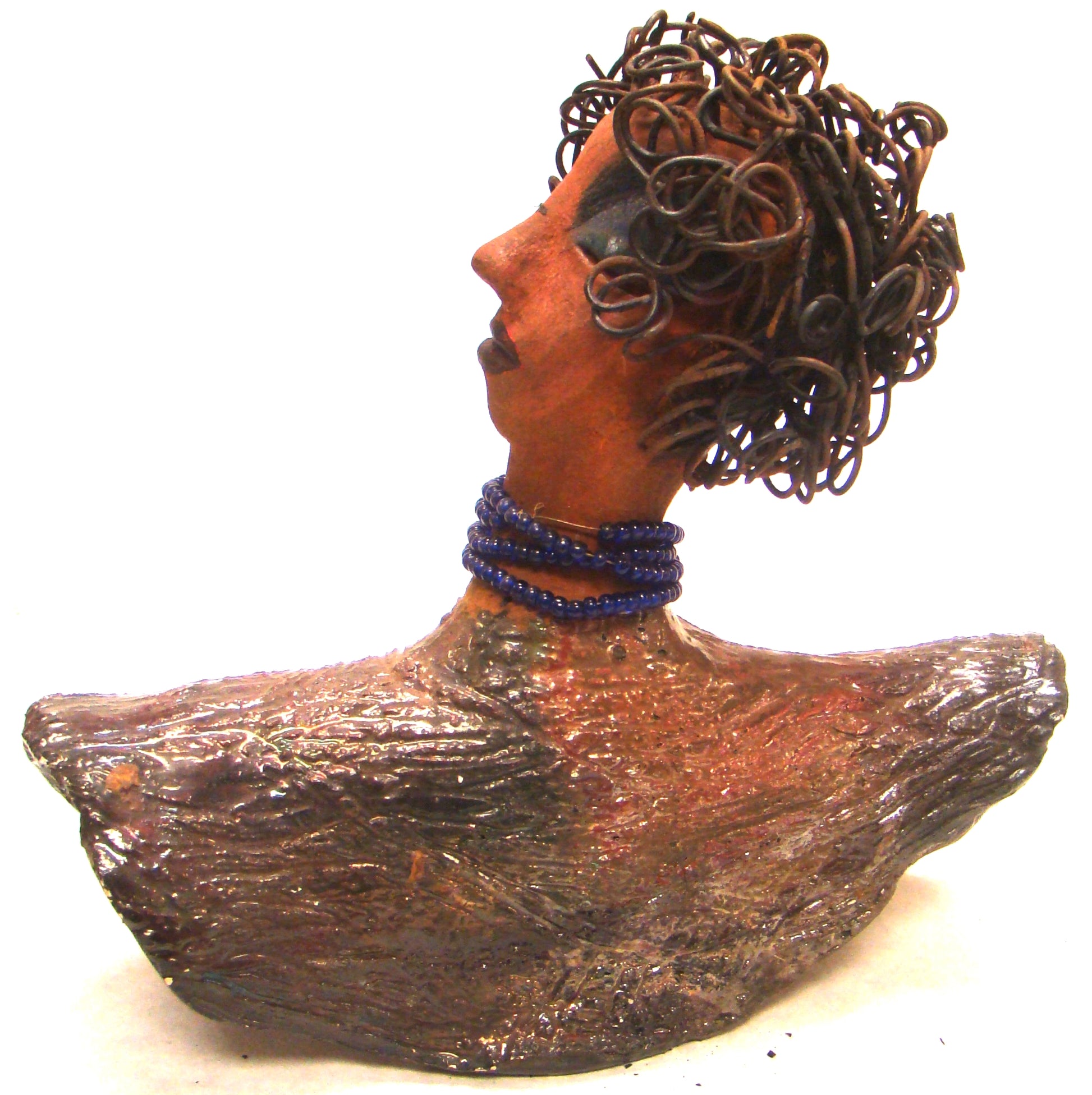Helen stands 8" x  8" x 3" and weighs 2.06 lbs. She has a lovely honey brown complexion. Helen has a metallic copper glaze on her textured robe. Her blue eye shadow matches the blue strand of beads around her neck. Helen has over 20 feet of curly wire hair. Helen is somewhat angelic! Give Helen a prominent place in your home!