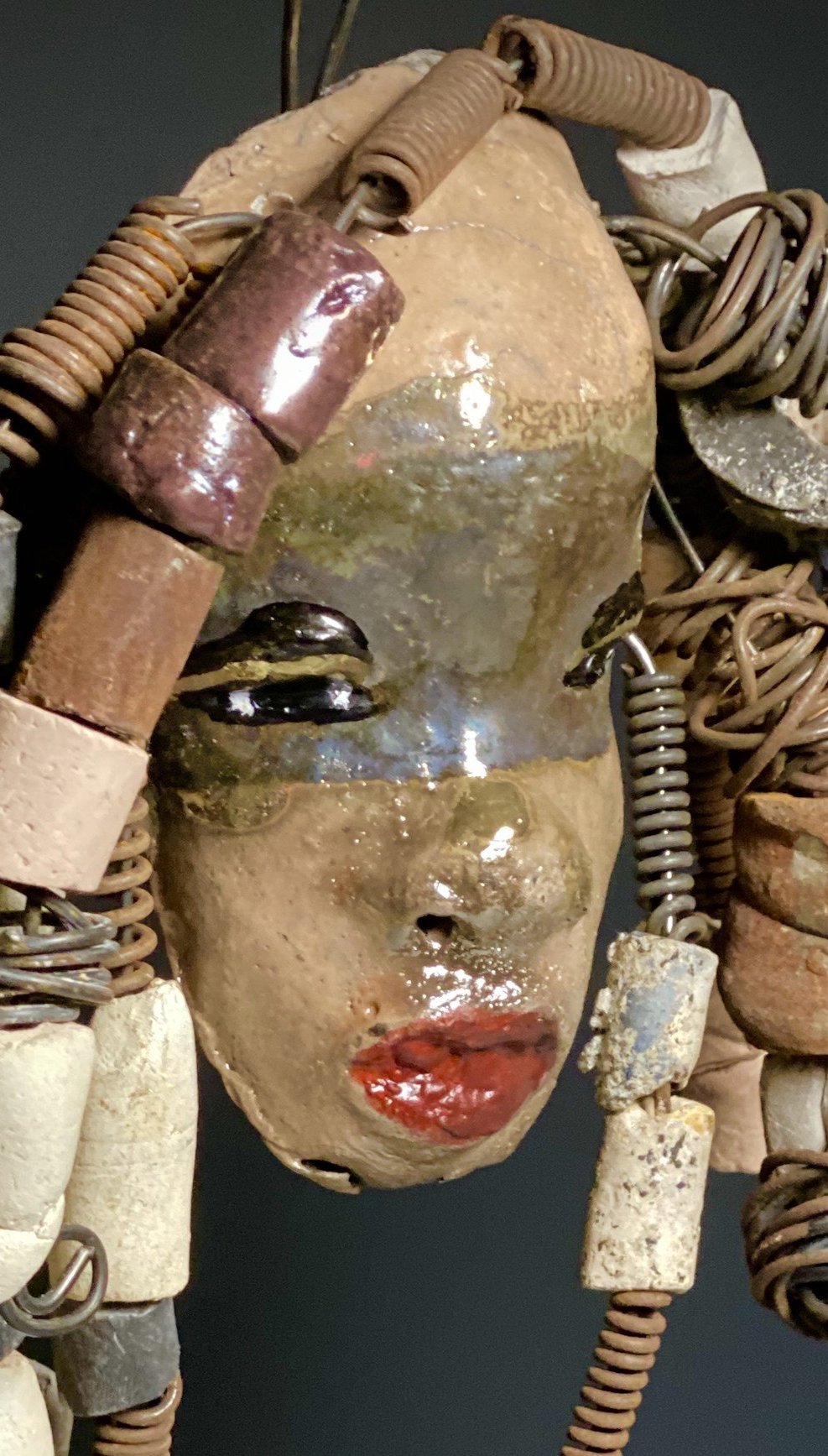 I started making art soon after seeing authentic African artwork at the Smithsonian Museum of African Art. I was in total awe. Audre was inspired by my visit there. Audre has a two tone copper gold complexion with ruby red lips. She is 7" x 5" and weighs 1.3 lbs. Audre has more than 30 handmade raku fired beads. Audre has over 15 feet of coiled 16 gauge wire hair.