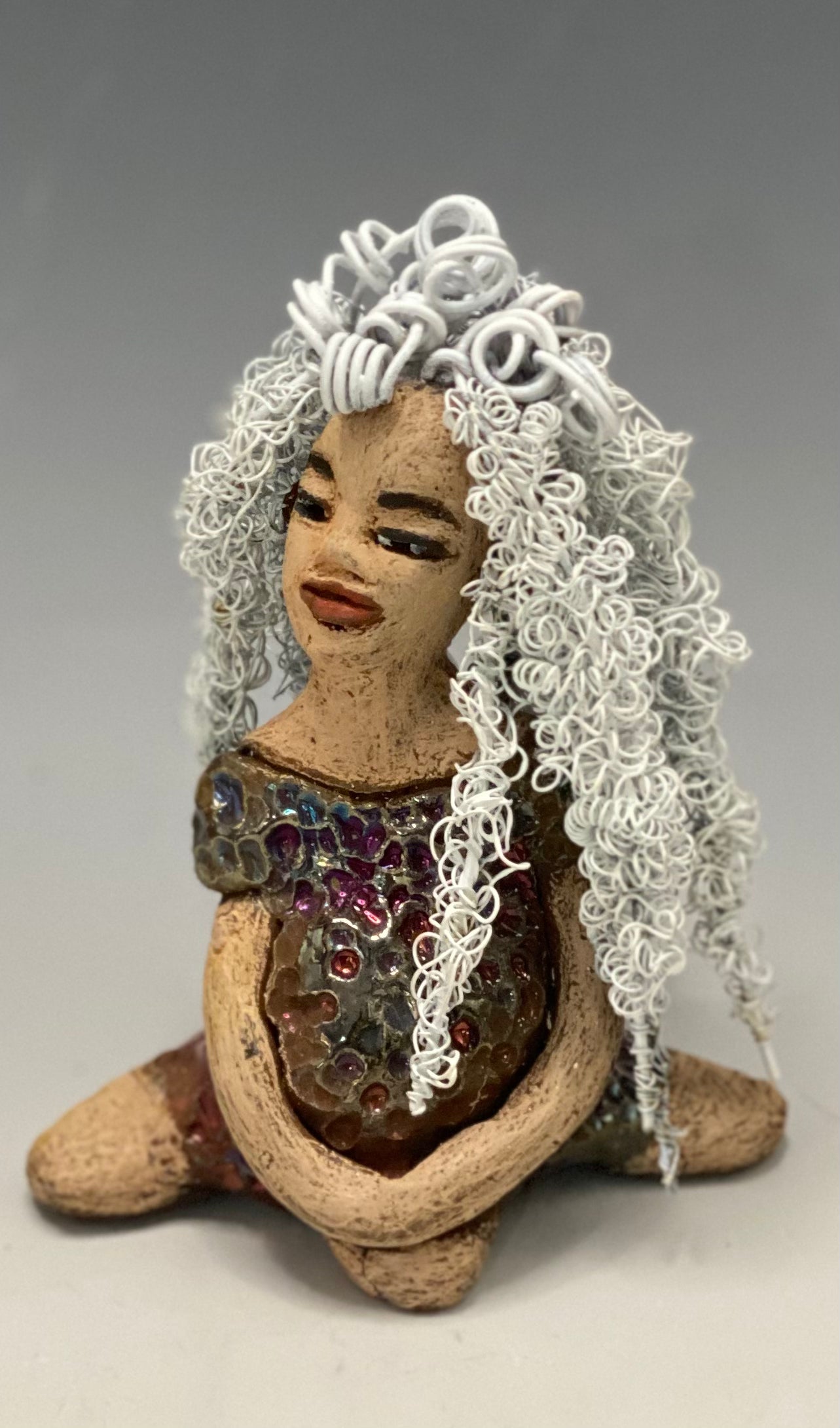 Alyssa stands 6" x 5" x 5" and weighs 12 ozs. She has a lovely honey brown complexion with cocoa brown lips. She has long twisted  white wire locs hairstyle waist down!  Alyssa has a metallic  copper antique glazed dress. She has over 75 feet of 16 and 24 gauge white wire for hair. It took over 3 hours just to do her hair! With  eyes wide opened, Brianna has hope of finding a new home.     You will love having Alyssa. She will attract and spark conversation with guest in your home!