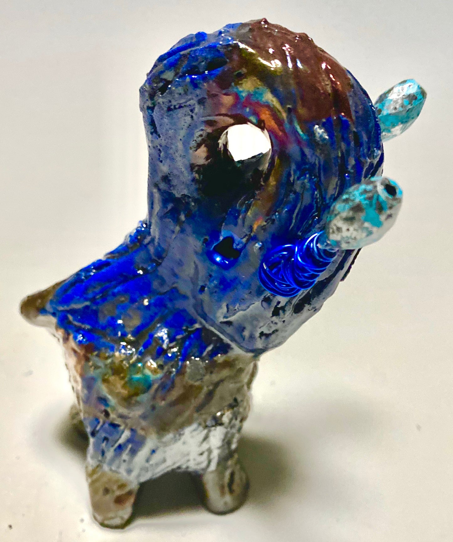 Raku Elephant Have you HERD!!!!!! Just one of these lovely Raku Fired Elephant will make an excellent gift for your friend, sorority or for your home’ special place centerpiece. 5" x 4" x 4" 9 ozs. Blue wire beaded blue tusk Beautiful metallic raku colors For decorative purposely only.