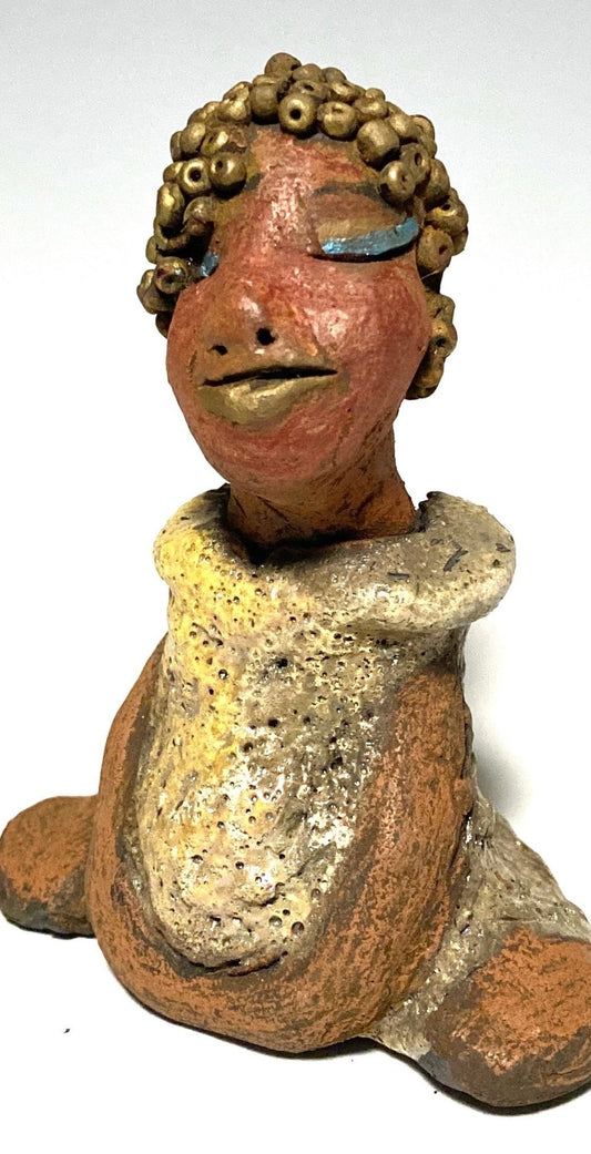 Meet Little Marissa! Marissa stands 4.5" x 4" x 2.5" and weighs 6.7 ozs.  Marissa has a lovely glossy gold dress.  She gold beaded hair. Marissa  appears to sit in a yoga pose. Her long arms rest at her side. Marissa is a great starter piece from the Herdew Collection!