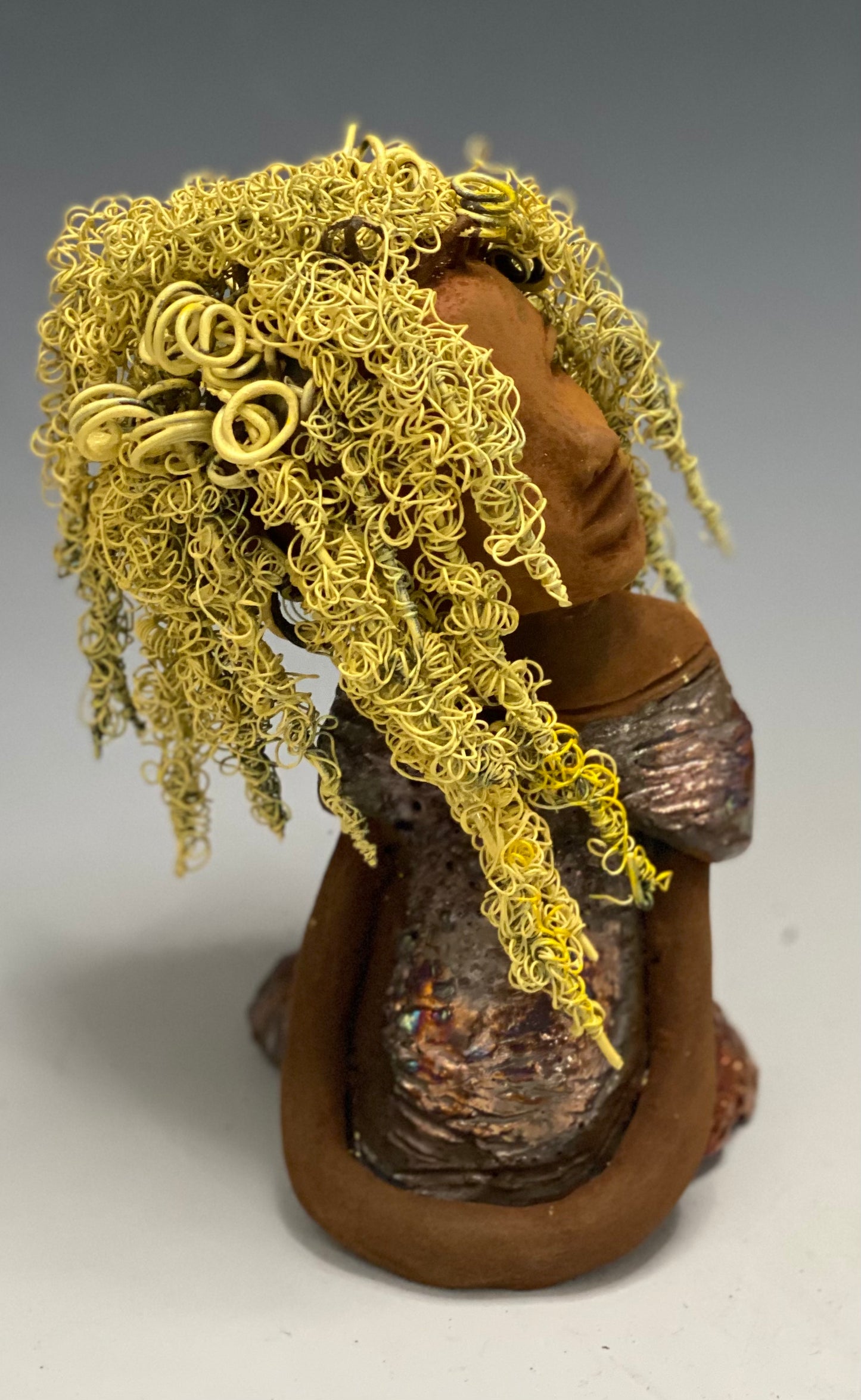 Valorie stands 8" x 4.5" x 4.5" and weighs 1.05 lbs. She has a lovely honey brown complexion with cocoa brown lips. She has long twisted wire locs hairstyle waist down! Valorie has a metallic copper antique glazed dress. She has over 75 feet of 16 and 24 gauge pale yellow wire for hair. It took over 7 hours just to do her hair! With eyes wide opened, Valorie has hope of finding a new home.