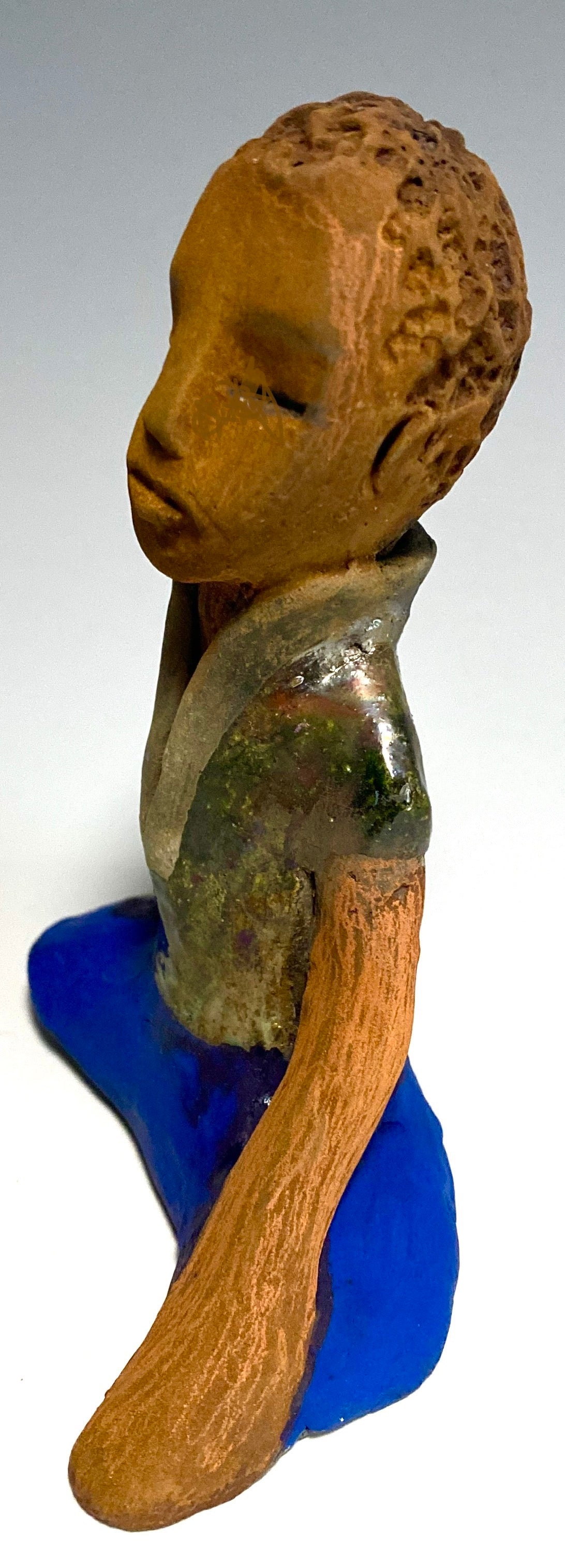 Travis is one teen who does respect his elders.   Travis stands  5" x 4" x 3" and weighs 9 ozs. He wears a metallic green shirt with blue jeans . Travis complexion is honey brown. He is thoughtful with a gentle spirit His  arms rest at his knees as he waits on you.