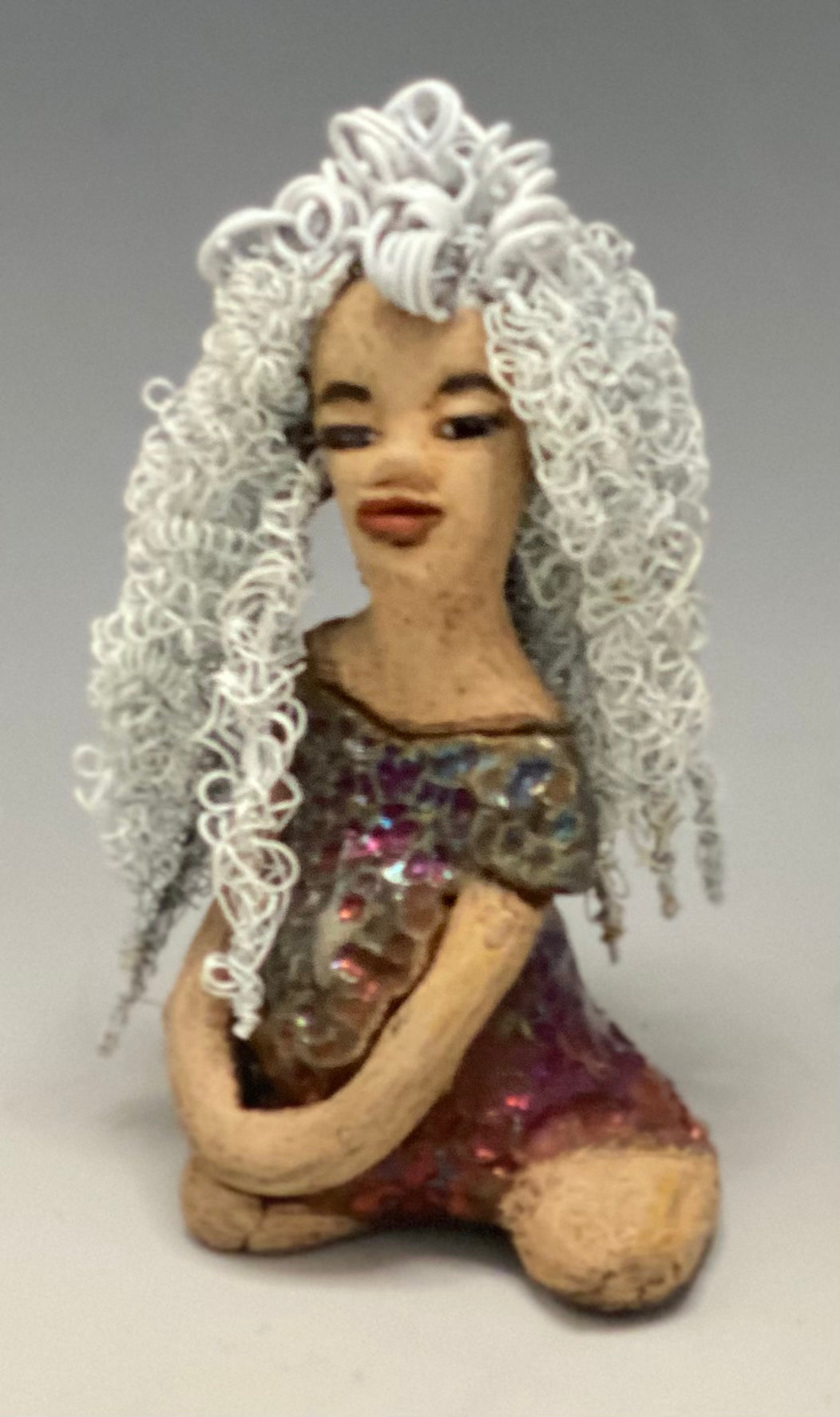 Alyssa stands 6" x 5" x 5" and weighs 12 ozs. She has a lovely honey brown complexion with cocoa brown lips. She has long twisted  white wire locs hairstyle waist down!  Alyssa has a metallic  copper antique glazed dress. She has over 75 feet of 16 and 24 gauge white wire for hair. It took over 3 hours just to do her hair! With  eyes wide opened, Brianna has hope of finding a new home.     You will love having Alyssa. She will attract and spark conversation with guest in your home!