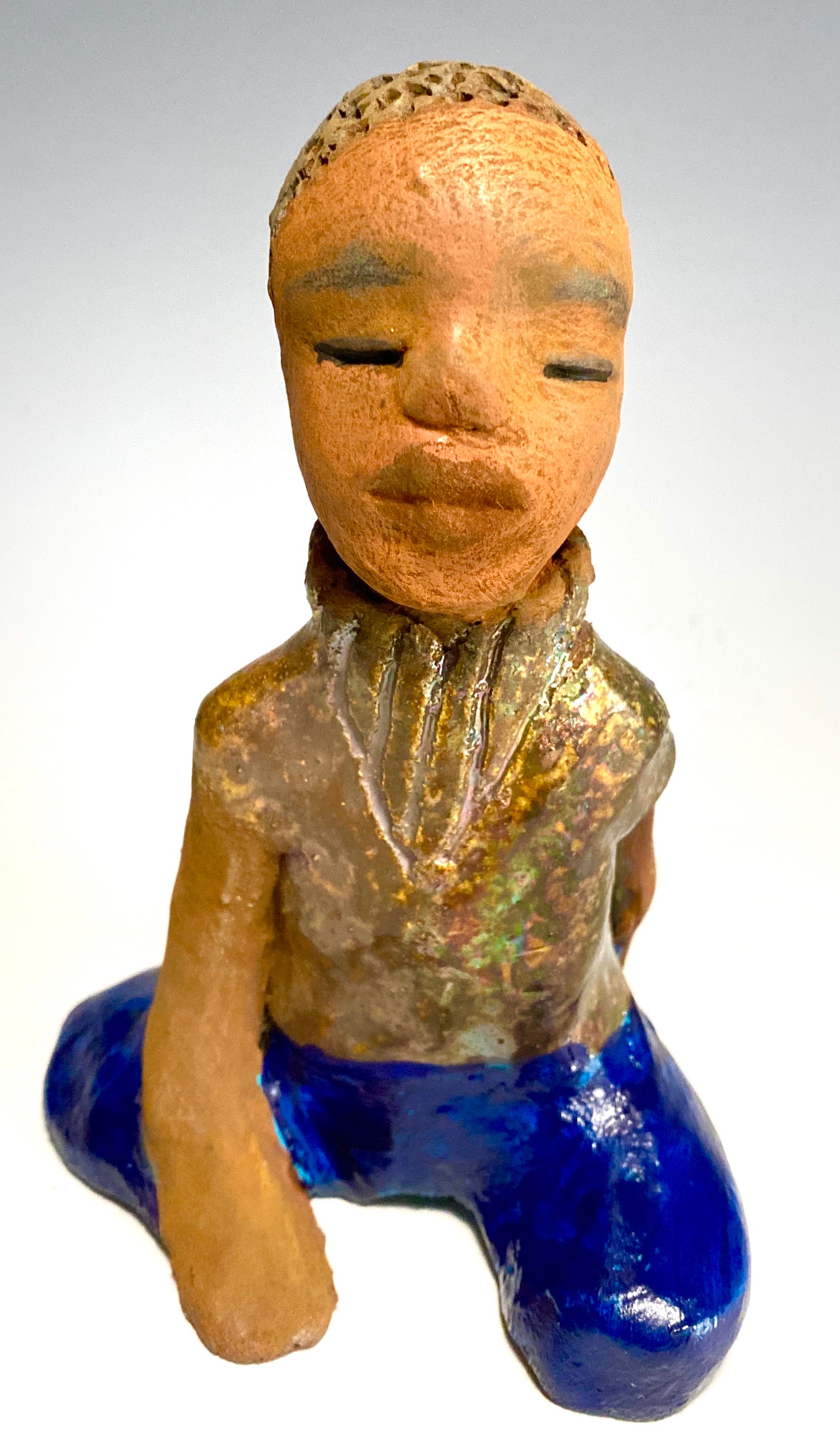 Anthony is one confident preteen who is ready to get back to school!     Anthony stands 5" x 4" x 4" and weighs 12 ozs. He has a metallic green and gold shirt with blue jeans . Anthony complexion is honey brown. He has a  youg gentle spirit One arms is  behind his back as he ponders who will be his favorite teacher.