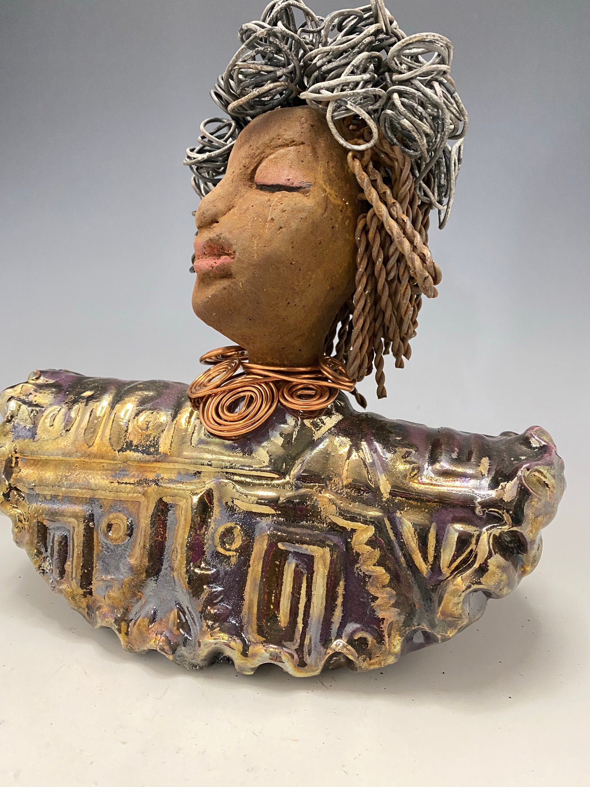 Meet Janet!  Janet looks up with joy and anticipation! She  stands 8" x 7" x 4" and weighs 2.70 lbs. She has a beautiful textured gold and  copper robe trim. Janet has braided ,twisted, and curled wire hair. She has a honey brown complexion and soft reddish brown lips. Janet will make for great conversation in your home.