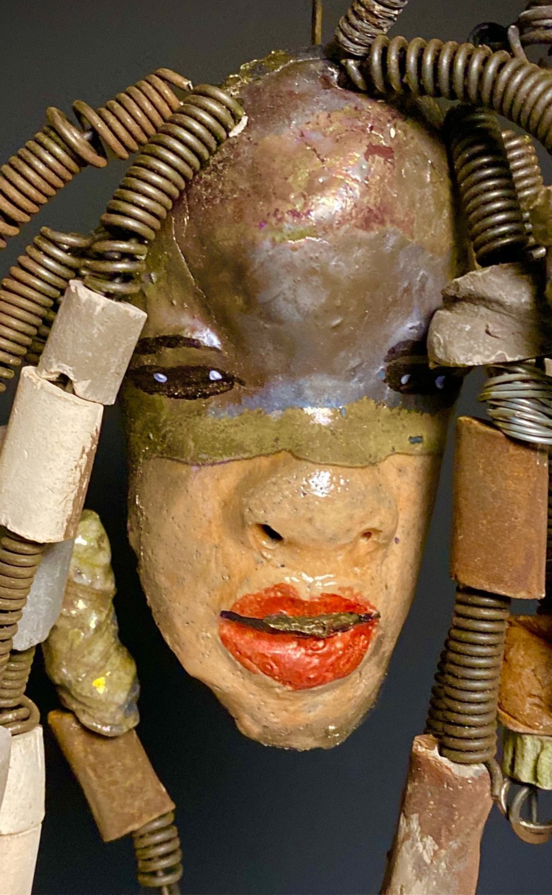 I started making art soon after seeing authentic African artwork at the Smithsonian Museum of African Art. I was in total awe. Kenna was inspired by my visit there. Kenna has a two tone light and dark honey metallic complexion. Her hair can be adjusted up to 11" x 10" and weighs 1. lbs Kenna has over 20 handmade multicolored raku fired beads. She has over 20 feet of coiled 16 gauge wire hair. Kenna is ready for display!