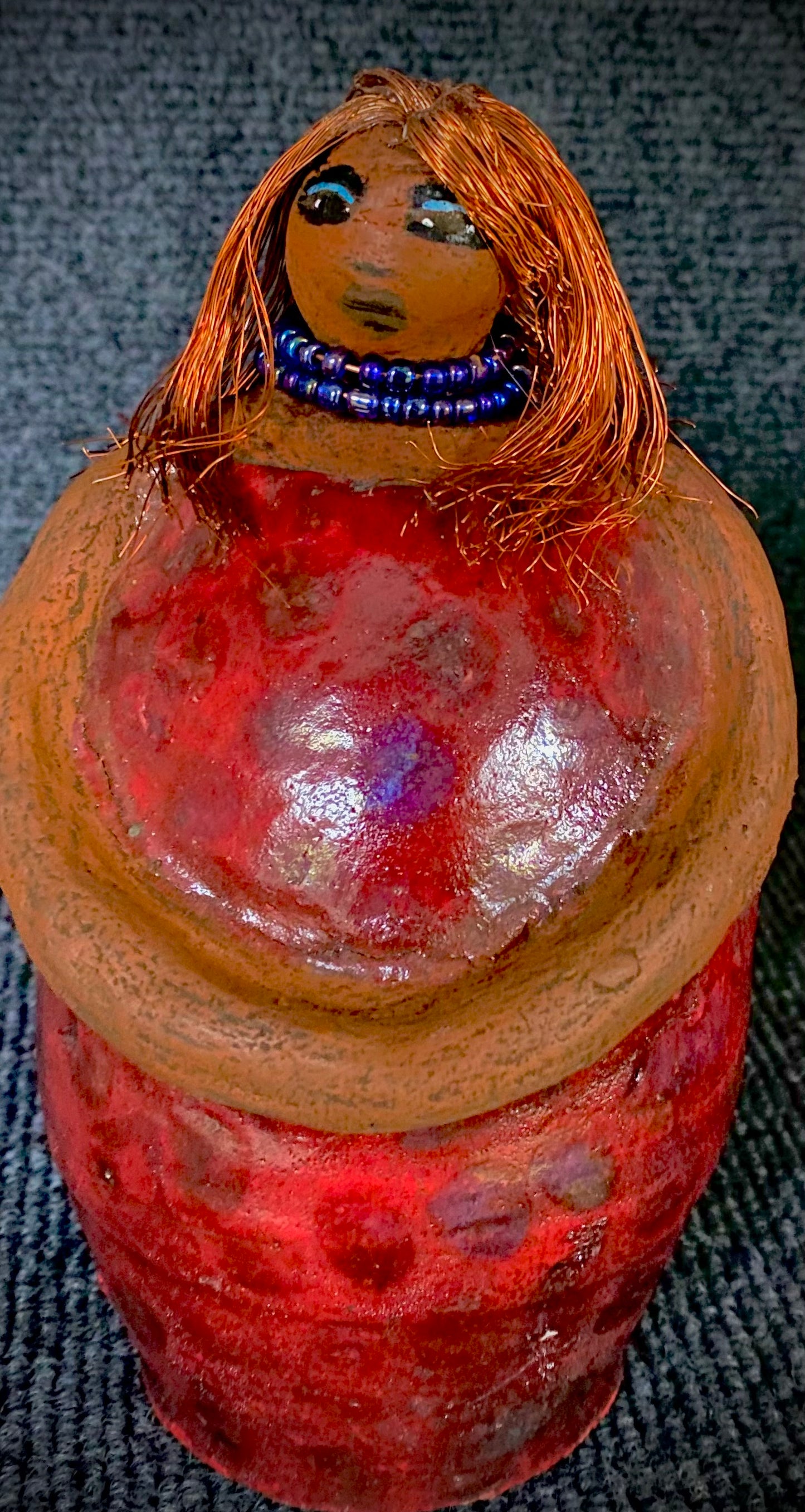 Meet Dora! She is a big girl who loves to sing and has aspirations of becoming a movie star. Dora stands 7" x 4" x 4.5" and weighs 1.06 lbs. She has a lovely honey brown complexion with lovely reddish brown lips. Dora has a lovely gold spotted heart glazed dress. She wears a beaded dark blue necklace. With eyes wide opened, Dora has hopes of finding a new home. Dora has a twin sister name Cora.