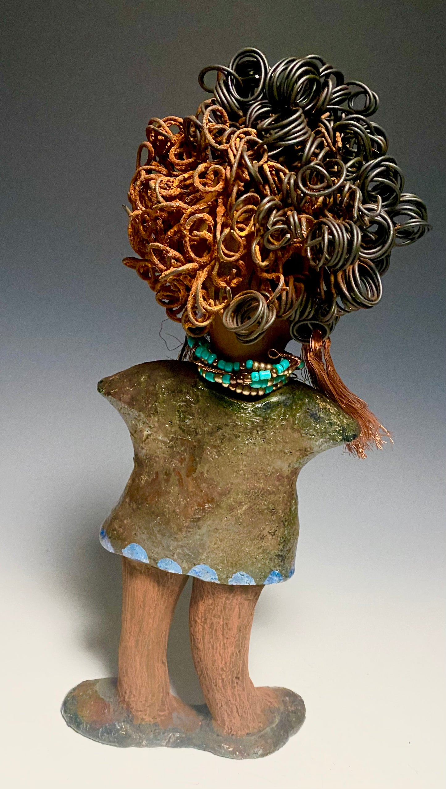 Meet Ernestine! What a joy to be around a young lady like Ernestine! She is one of many who has a polite gentle spirit! Ernestine stands 13" x 5" x 4" and weighs 3.19 lbs. Ernestine has a lovely honey brown complexion. Her hair is made of multiple strands of thin copper wire and two tone black and rusted 16 gauge wire. She has a textured colorful copper metallic dress. Ernestine is a young woman full of pride and joy. If you like sophisticated sculptures, Ernestine will bring joy and peace to your home.