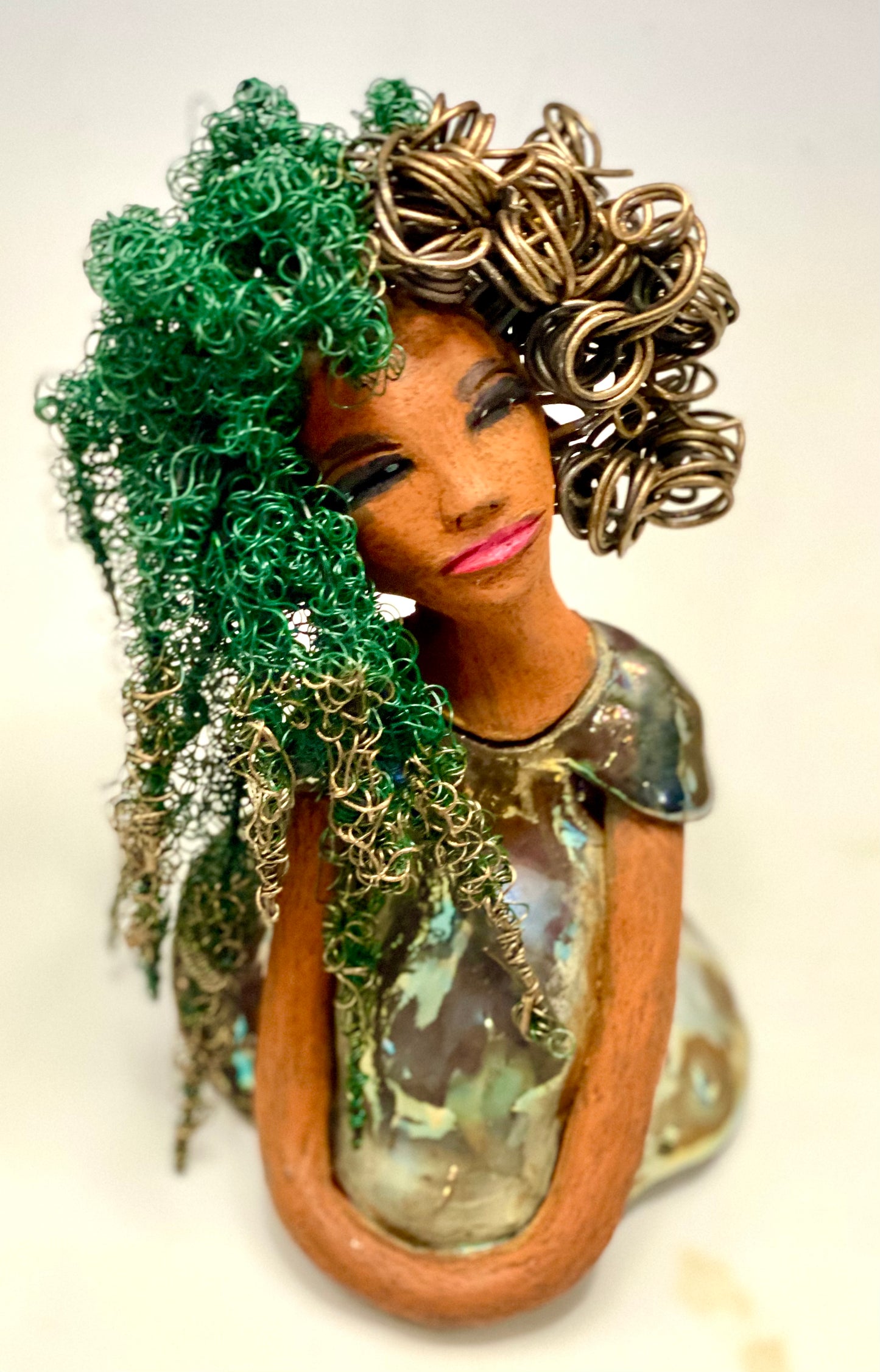 Diane stands 7" x 6" x 5.5" and weighs 1.9 lbs. She has a lovely honey brown complexion with reddish brown lips. She has long twisted wire locs hairstyle waist down! Diane has a very colorful metallic copper green antique glazed dress. She has over 75 feet of 16 and 24 gauge wire for hair. It took over 6 hours just to do her hair! With eyes wide opened, Diane has hope of finding a new home.