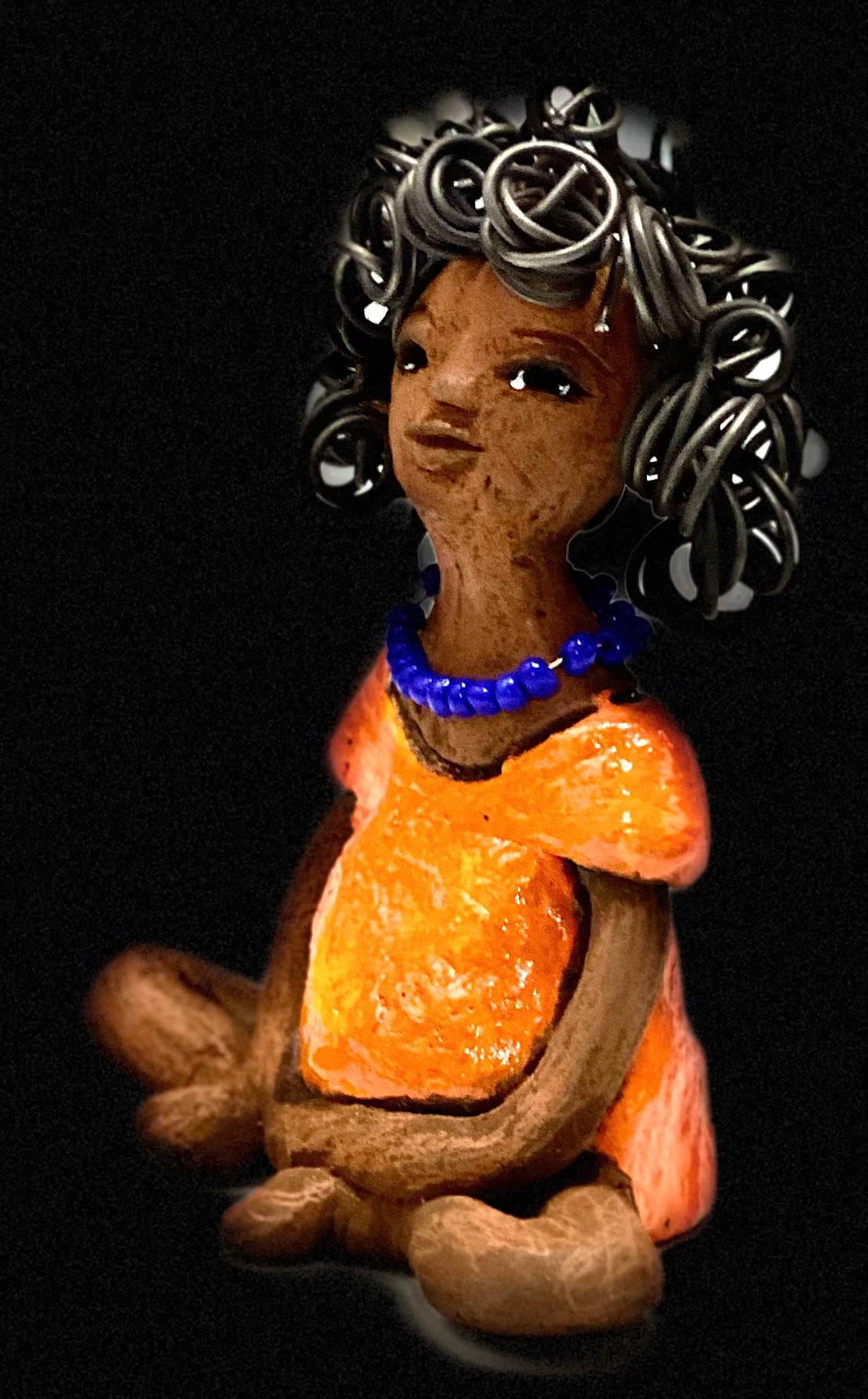 Asia stands 5" x 4" x 3.5" and weighs 8.75 ozs. She has a lovely honey brown complexion with cocoa brown lips. She has a really big curly hairstyle! Asia has beautiful a orange dress dress accented with a blue beaded necklace! . She has over 15 feet of 16 gauge wire for hair. It took over 2 hours just to do her hair! With eyes wide opened, Asia has hope of finding a new home.