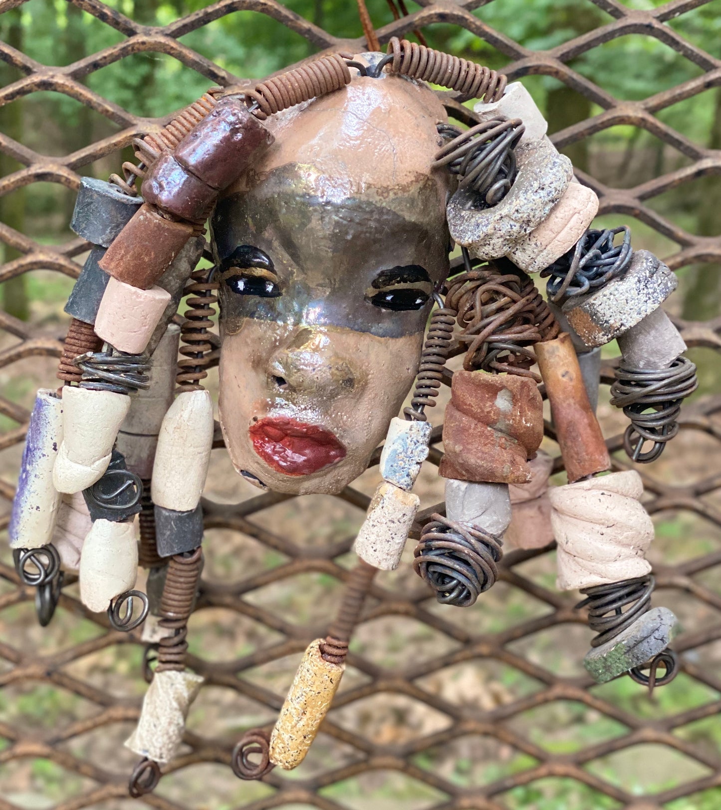 I started making art soon after seeing authentic African artwork at the Smithsonian Museum of African Art. I was in total awe. Audre was inspired by my visit there. Audre has a two tone copper gold complexion with ruby red lips. She is 7" x 5" and weighs 1.3 lbs. Audre has more than 30 handmade raku fired beads. Audre has over 15 feet of coiled 16 gauge wire hair.