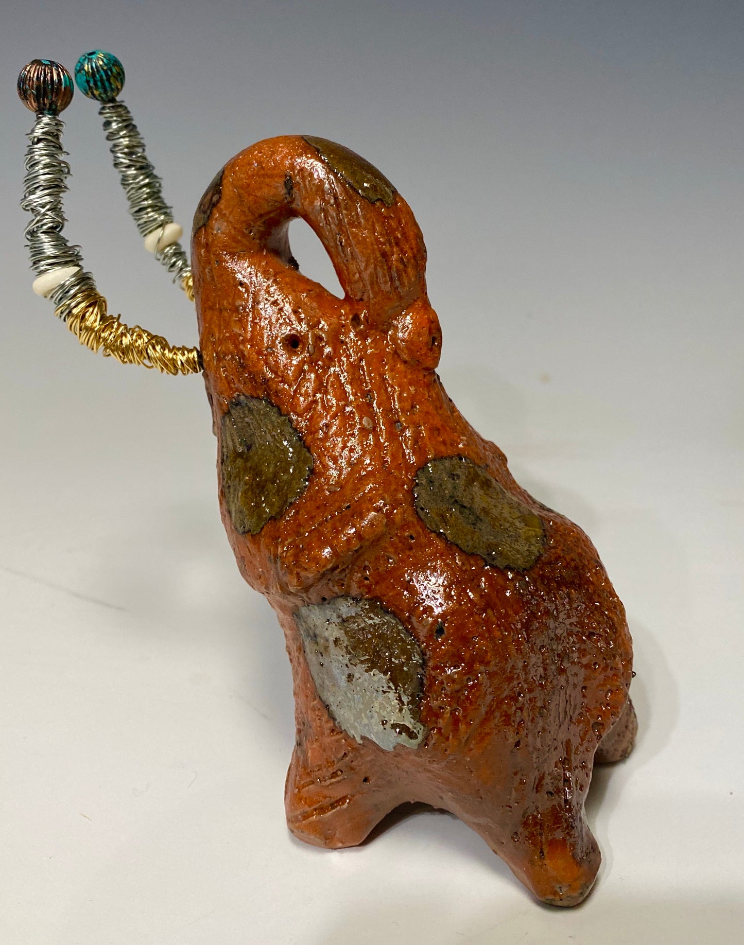 Raku Elephant Have you HERD!!!!!! Just one of these lovely Raku Fired Elephant will make an excellent gift for your friend, sorority or for your home’ special place centerpiece. 7" x 4" x 3" 11 ozs. Beautiful metallic gold and orange raku elephant For decorative purposely only.