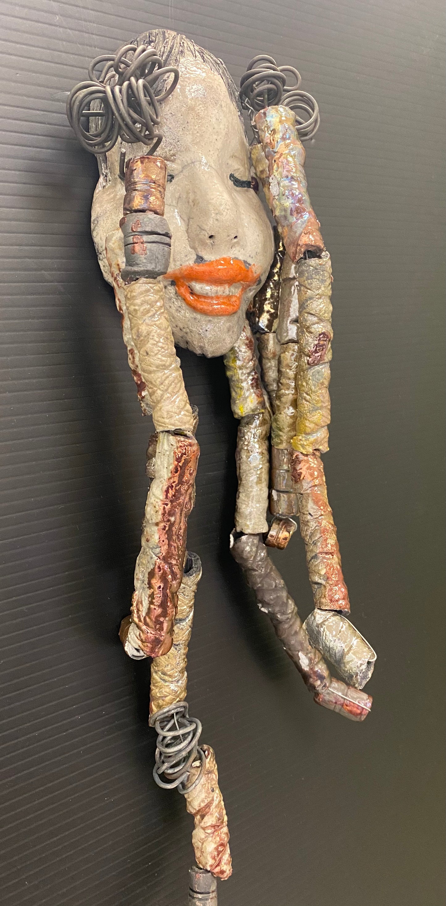 I started making art soon after seeing authentic African artwork at the Smithsonian Museum of African Art. I was in total awe. Trinity was inspired by my visit there. Trinity is 5”x 13” and weighs 11ozs. She has an off white complexion with ruby red lips. Trinity has five dreads of beads and spiral wire coils of hair. She is ready to be installed in your home!