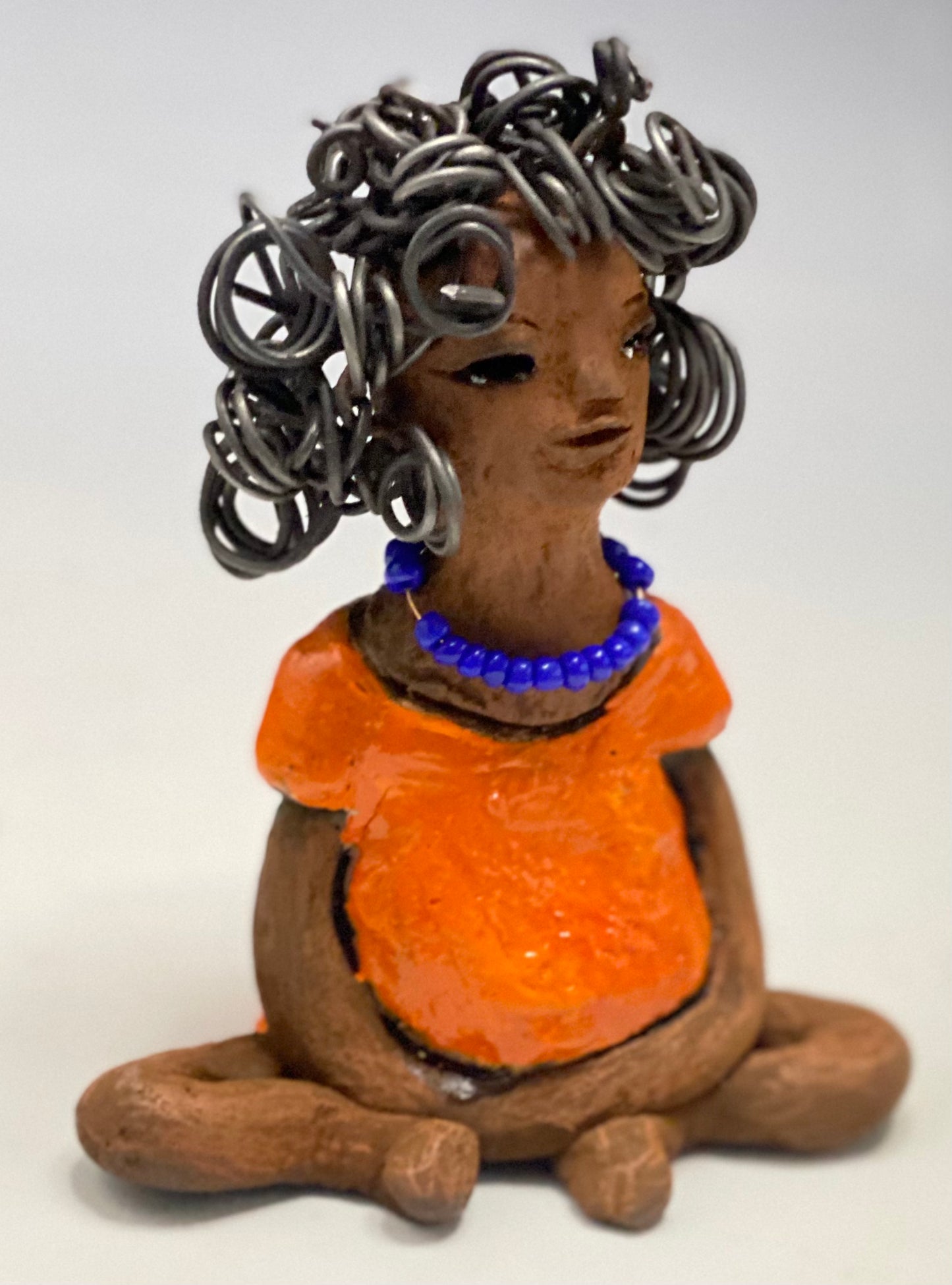 Asia stands 5" x 4" x 3.5" and weighs 8.75 ozs. She has a lovely honey brown complexion with cocoa brown lips. She has a really big curly hairstyle! Asia has beautiful a orange dress dress accented with a blue beaded necklace! . She has over 15 feet of 16 gauge wire for hair. It took over 2 hours just to do her hair! With eyes wide opened, Asia has hope of finding a new home.