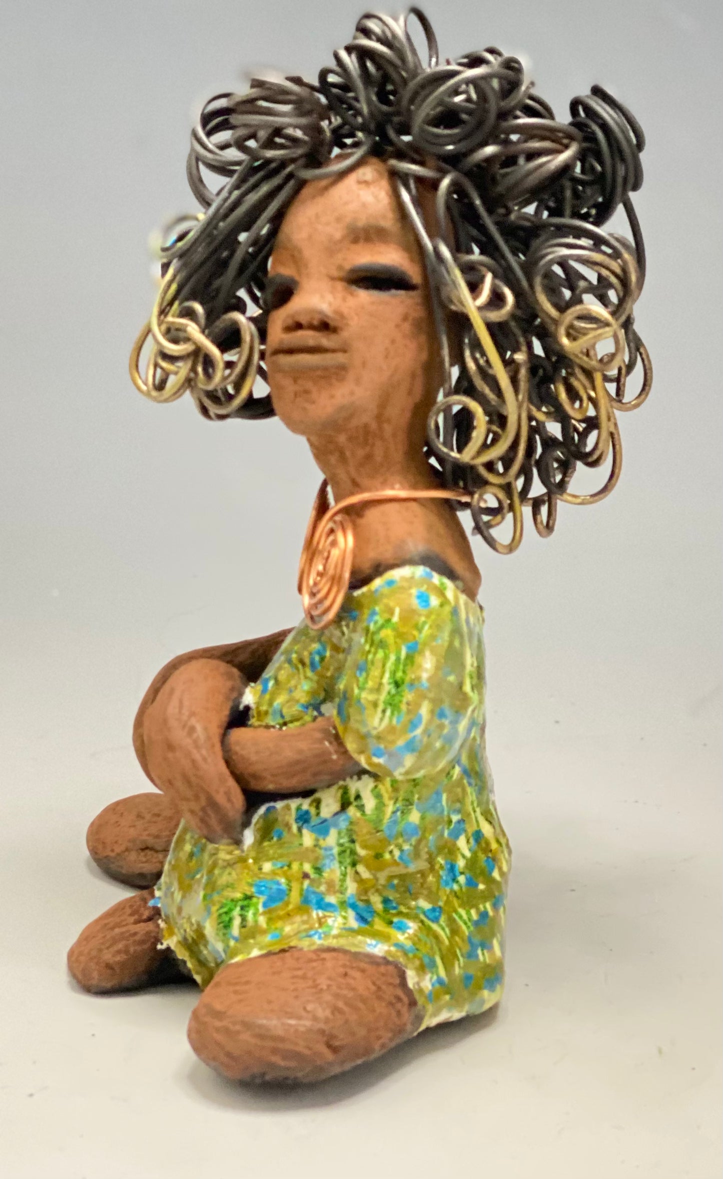 Jayla stands 7" x 5" x 4.5" and weighs 14 ozs. She has a lovely honey brown complexion with cocoa brown lips. She has a big hairstyle! Brianna has a colorful blue green antique glazed dress. She has over 15 feet of 16 gauge wire for hair. It took over 2hours just to do her hair! With eyes wide opened, Jayla has hope of finding a new home. You will love having Jayla! She will attract and spark conversation with guest in your home!