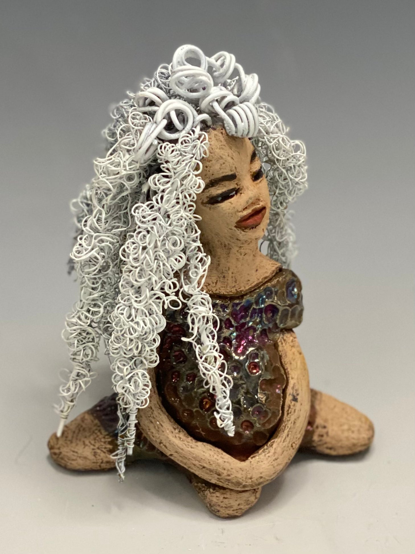 Alyssa stands 6" x 5" x 5" and weighs 12 ozs. She has a lovely honey brown complexion with cocoa brown lips. She has long twisted  white wire locs hairstyle waist down!  Alyssa has a metallic  copper antique glazed dress. She has over 75 feet of 16 and 24 gauge white wire for hair. It took over 3 hours just to do her hair! With  eyes wide opened, Brianna has hope of finding a new home.     You will love having Alyssa. She will attract and spark conversation with guest in your home!