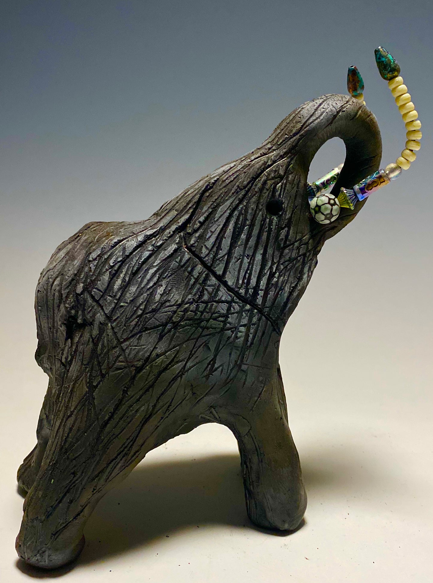 Raku Elephant Have you HERD!!!!!! Just one of these lovely Raku Fired Elephant will make an excellent gift for your friend, sorority or for your home’ special place centerpiece. 7" x 4" x 4" 1.7 lbs Beautiful metallic matte raku elephant For decorative purposely only