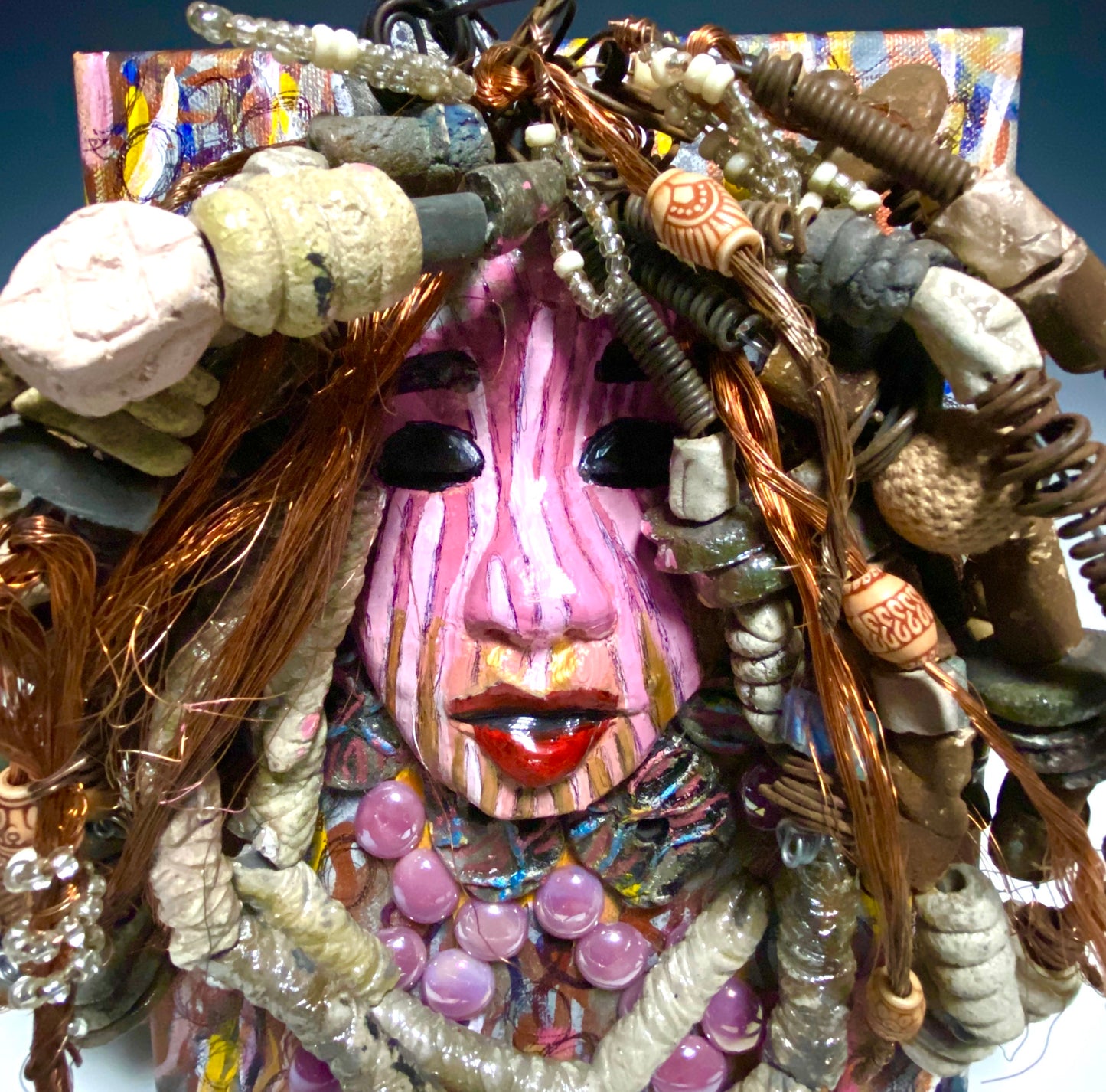 Sabra is mounted on a 8"x 10"painted canvas. I spent about 4 hours or more just fixing April's hair and attaching her beads! She has over 60 feet of 16 gauge wire with multiple strands of copper wire for hair and over 50 raku beads. Sabra has a striped pink crackle face with and ruby red lips. She is ready to be hung!
