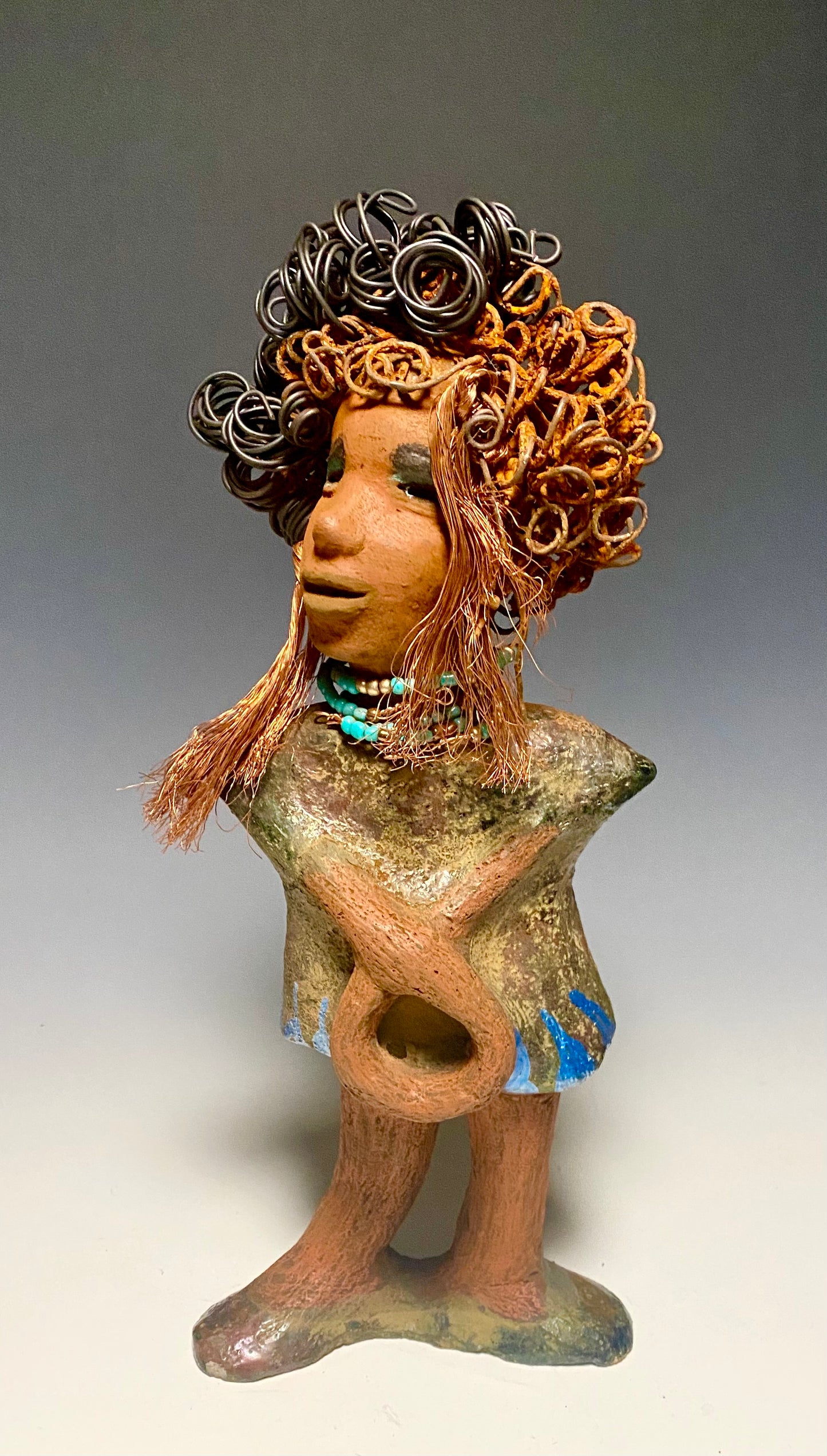 Meet Ernestine! What a joy to be around a young lady like Ernestine! She is one of many who has a polite gentle spirit! Ernestine stands 13" x 5" x 4" and weighs 3.19 lbs. Ernestine has a lovely honey brown complexion. Her hair is made of multiple strands of thin copper wire and two tone black and rusted 16 gauge wire. She has a textured colorful copper metallic dress. Ernestine is a young woman full of pride and joy. If you like sophisticated sculptures, Ernestine will bring joy and peace to your home.