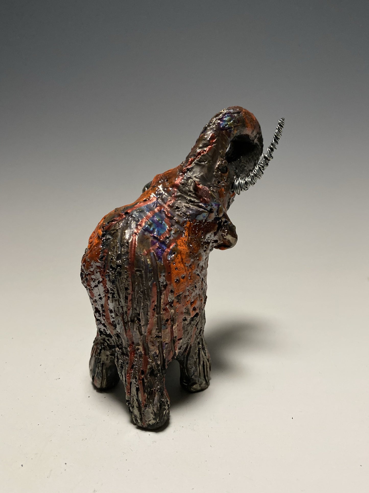 Raku Elephant Have you HERD!!!!!! Just one of these lovely Raku Fired Elephant will make an excellent gift for your friend, sorority or for your home’ special place centerpiece. 6" x 3" x 4" 11 ozs. Beautiful metallic orange raku elephant For decorative purposely only