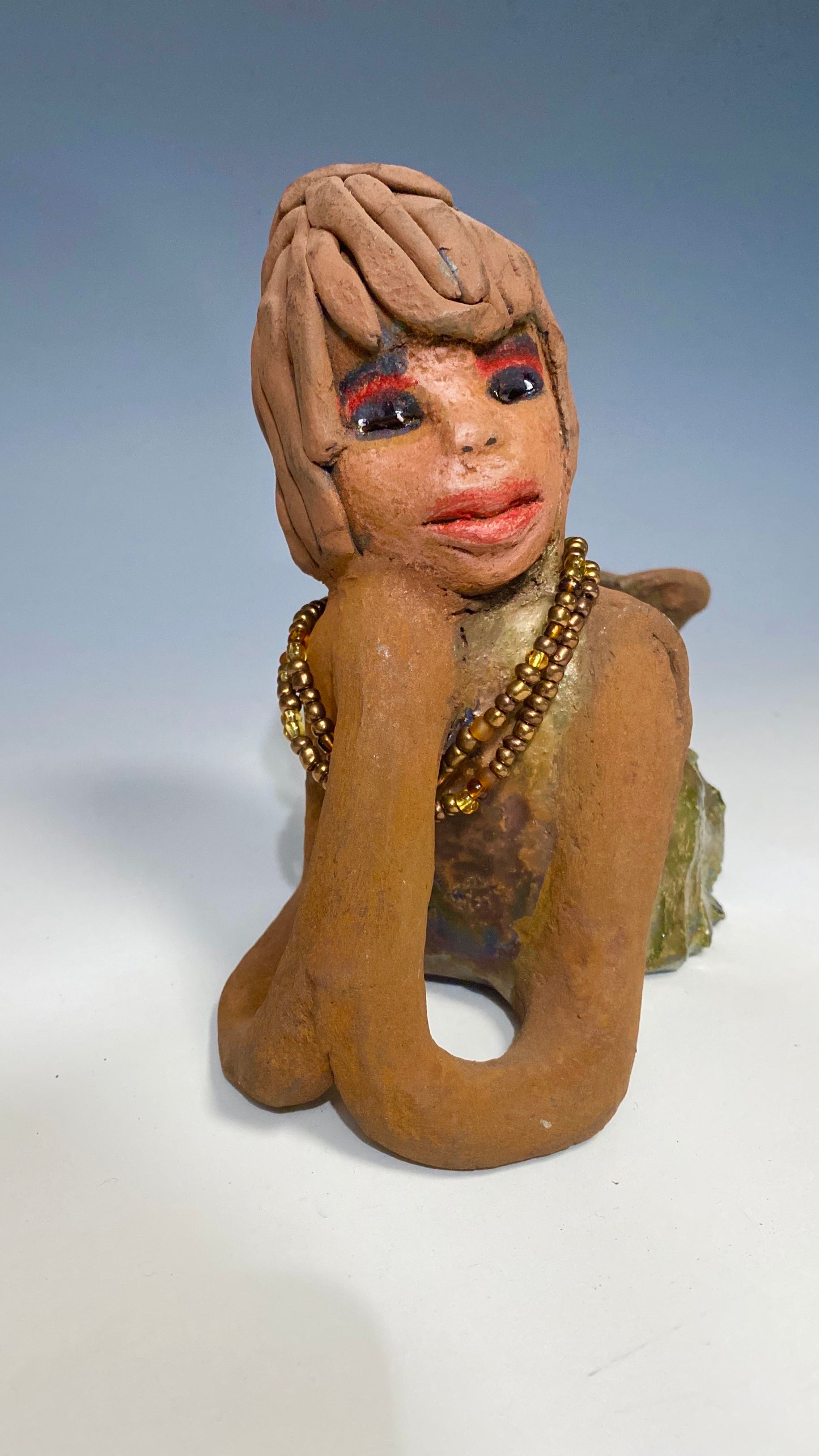 Meet Devonte! Devonte stands 8" x 6" x 4" and weighs 1.06 lbs. Devonte has a awesome honey brown complexion. She has braided clay hair. Devonte has long loving arms. She wears a metallic copper dress with red orange beads. Give Devonte a special place in your home!