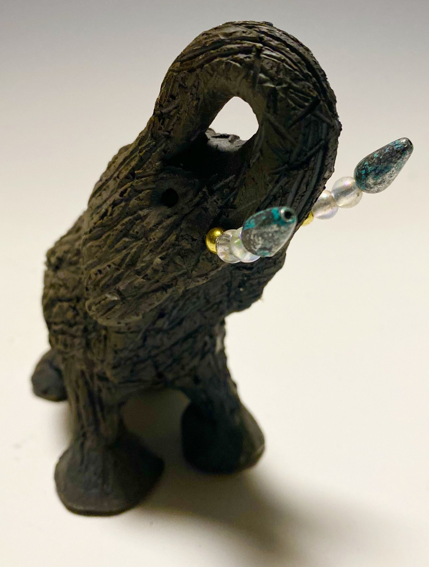 Elephants are one of my favorite animals to create. They are so majestic" Just one of these lovely Raku Fired Elephant will make an excellent gift for your BFF, or just for you . This raku fired elephant stands 7" x 2" x 2.5" and weighs 7 ounces. She has beaded tusks and a textured charcoal body. Nice!