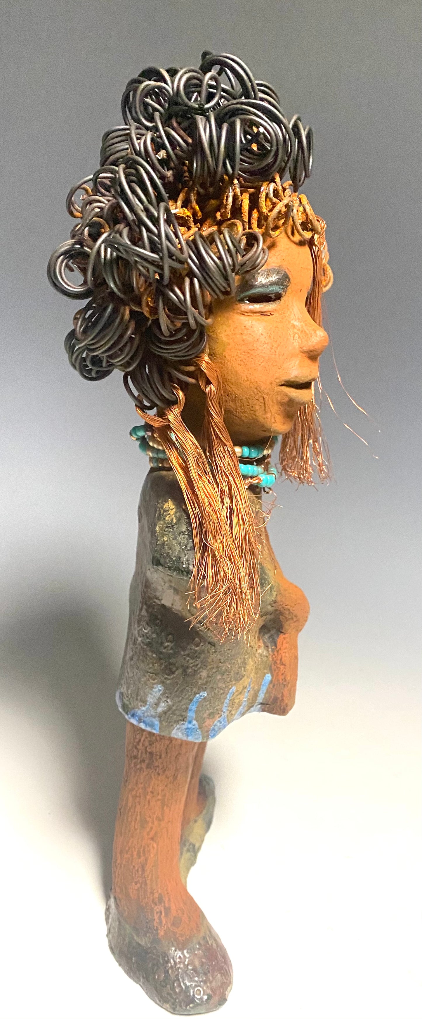 Meet Ernestine! What a joy to be around a young lady like Ernestine! She is one of many who has a polite gentle spirit! Ernestine stands 13" x 5" x 4" and weighs 3.19 lbs. Ernestine has a lovely honey brown complexion. Her hair is made of multiple strands of thin copper wire and two tone black and rusted 16 gauge wire. She has a textured colorful copper metallic dress. Ernestine is a young woman full of pride and joy. If you like sophisticated sculptures, Ernestine will bring joy and peace to your home.