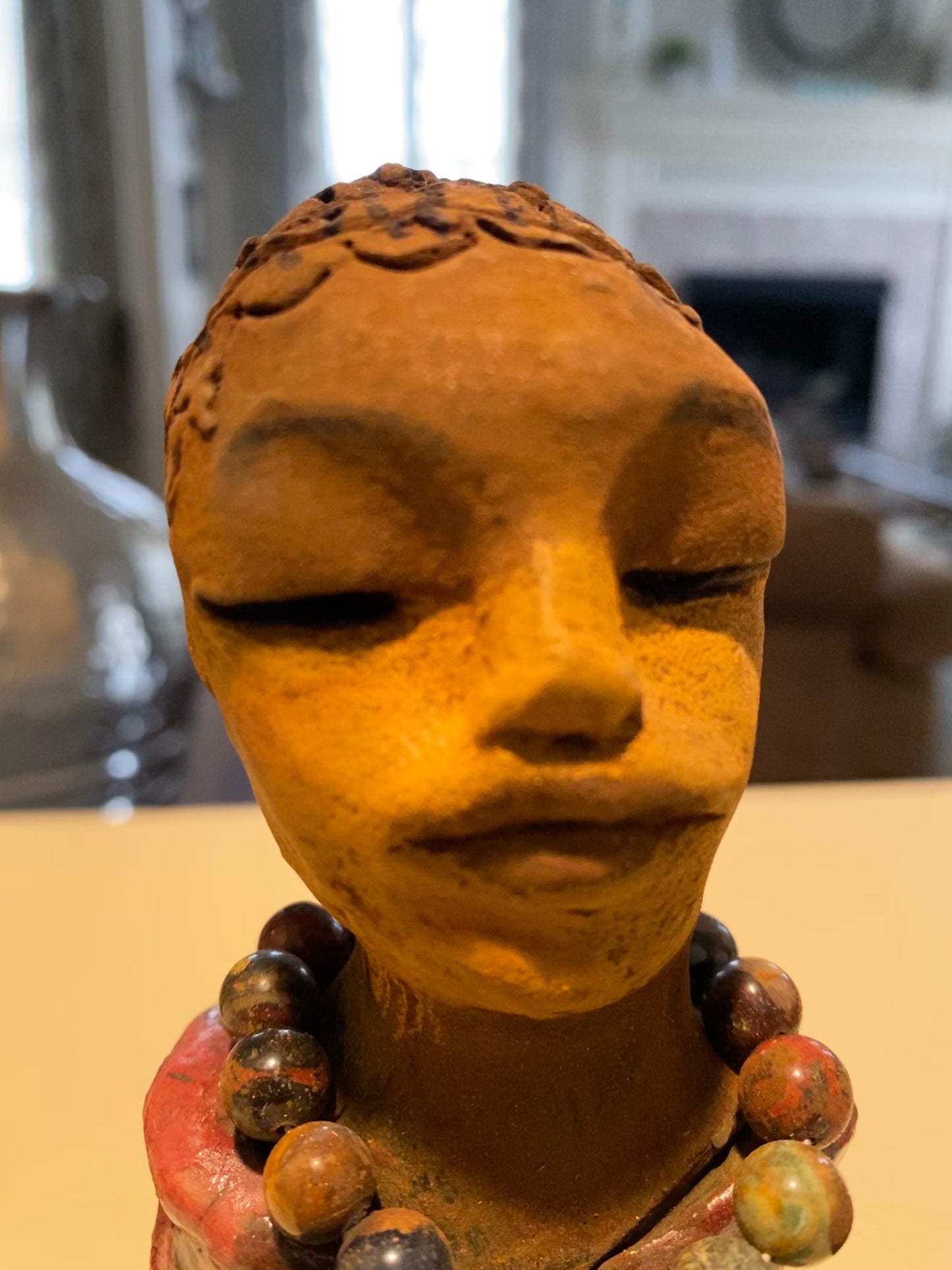 Mena long loving arms rest beside her multicolored copper green dress. Mena is a sophisticated lady that will grace your home.