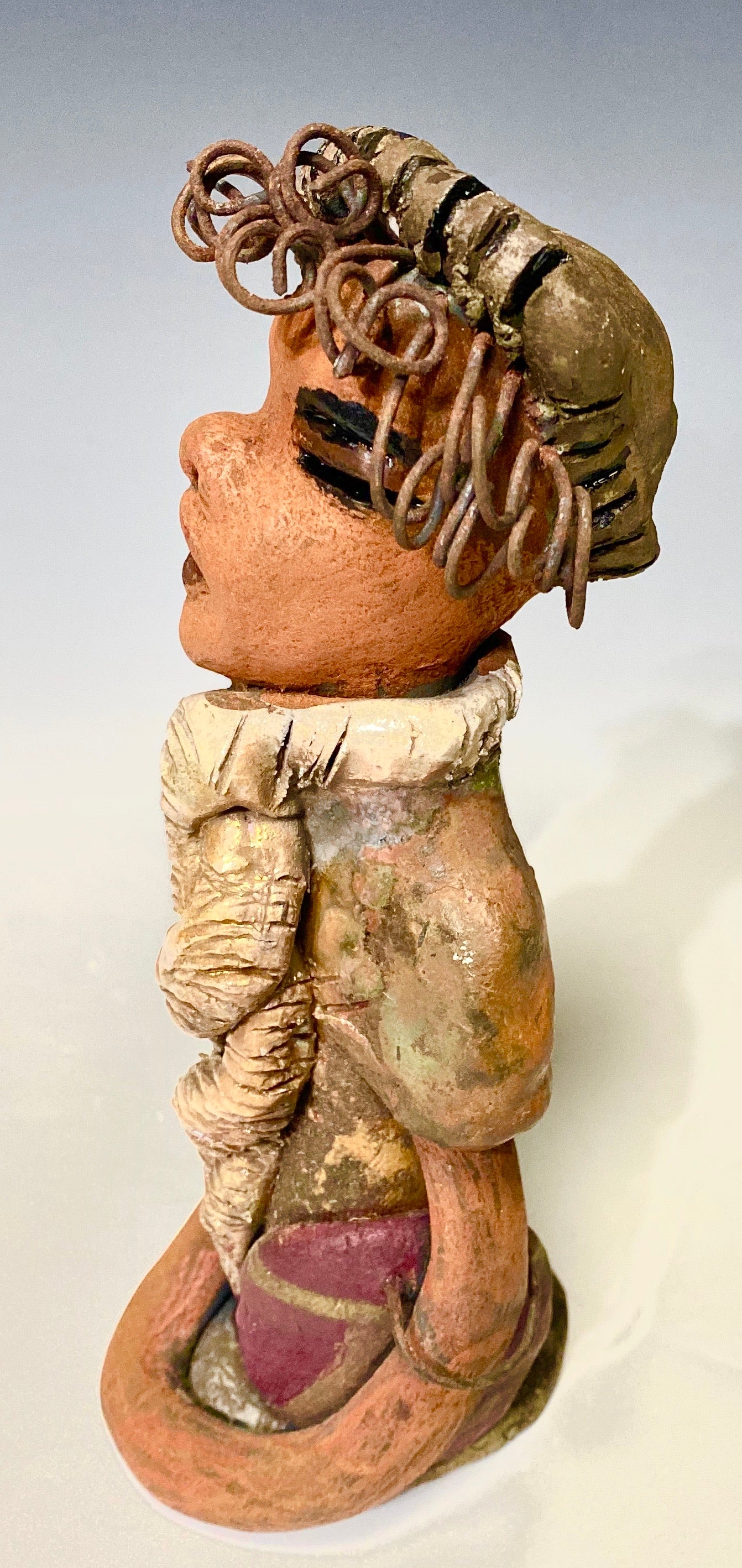 Lorie sits 8" x 3 x 3" and weighs 1.11 lbs. Lorie complexion is cocoa brown. She wears a  dark brown metallic and matte dress. Lorie sits with her arms and purse at her side. She will be a great gift or bring happiness to your home!