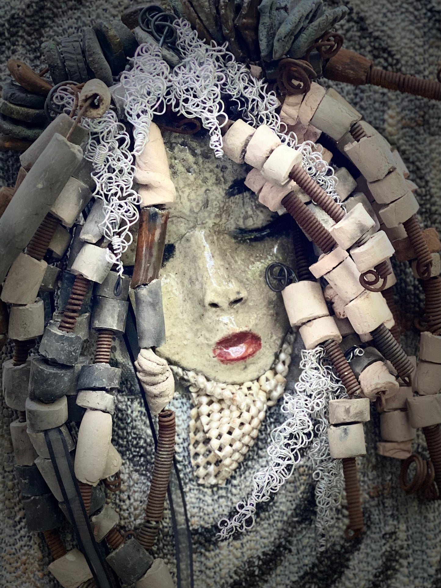 I started making art soon after seeing authentic African artwork at the Smithsonian Museum of African Art. I was in total awe. Sergio was inspired by my visit there. Sergio is mounted on a 8"x 10" painted canvas. I spent about 4 hours or more just fixing Sergio's hair and attaching beads! Sergio has over 40 feet of 16 gauge wire for hair and over 30 raku beads. Sergio has a white crackle face with ruby red lips. He weighs 2.10 lbs and is ready to be hung!