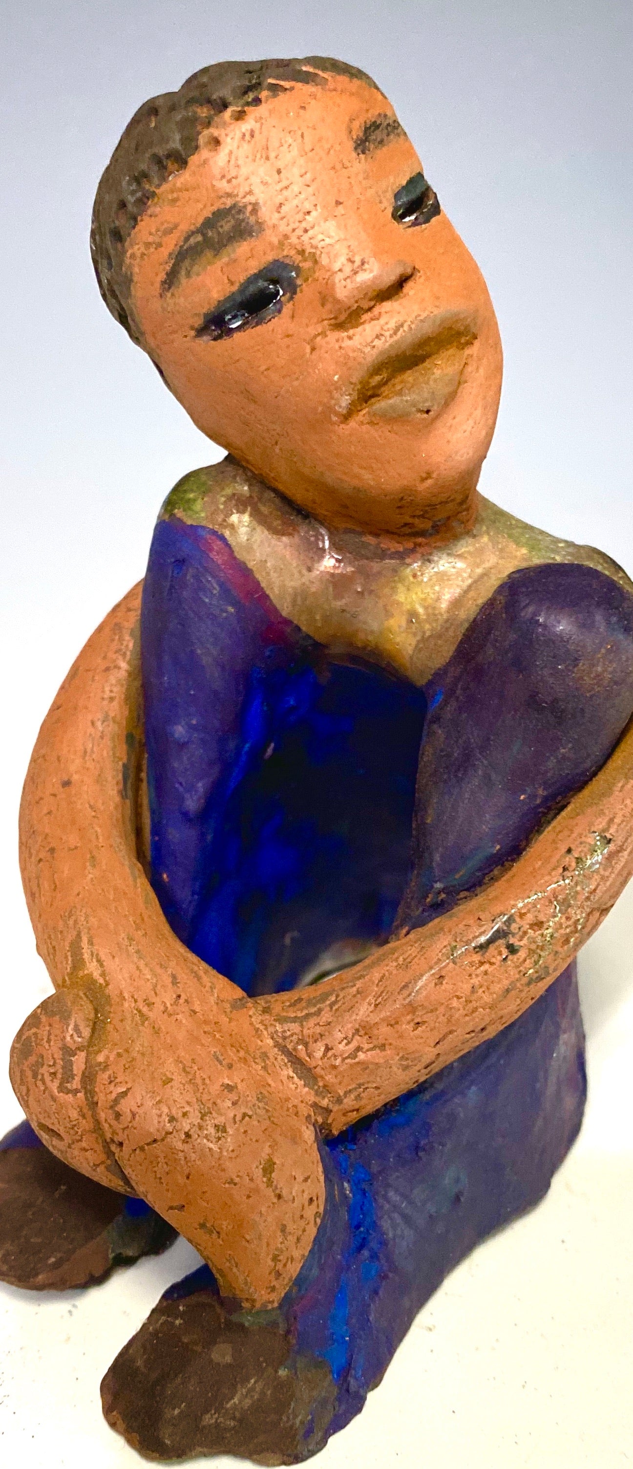 Paul is a Handsome Mischief Guy! Do you see the wit in his face? Paul stands 4.5"x 3" x 3" and weighs 6.9 ozs. He has a shimmery metallic tee shirt. Paul's complexion is honey brown. His arms are folded around his legs as he ponders another mischief moment!