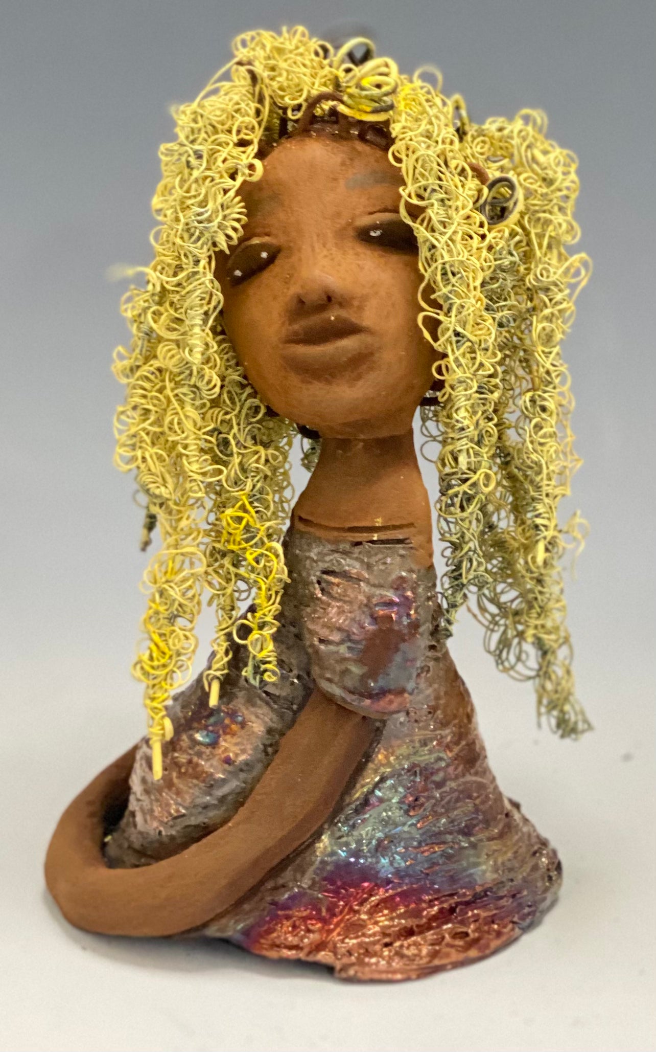 Valorie stands 8" x 4.5" x 4.5" and weighs 1.05 lbs. She has a lovely honey brown complexion with cocoa brown lips. She has long twisted wire locs hairstyle waist down! Valorie has a metallic copper antique glazed dress. She has over 75 feet of 16 and 24 gauge pale yellow wire for hair. It took over 7 hours just to do her hair! With eyes wide opened, Valorie has hope of finding a new home.