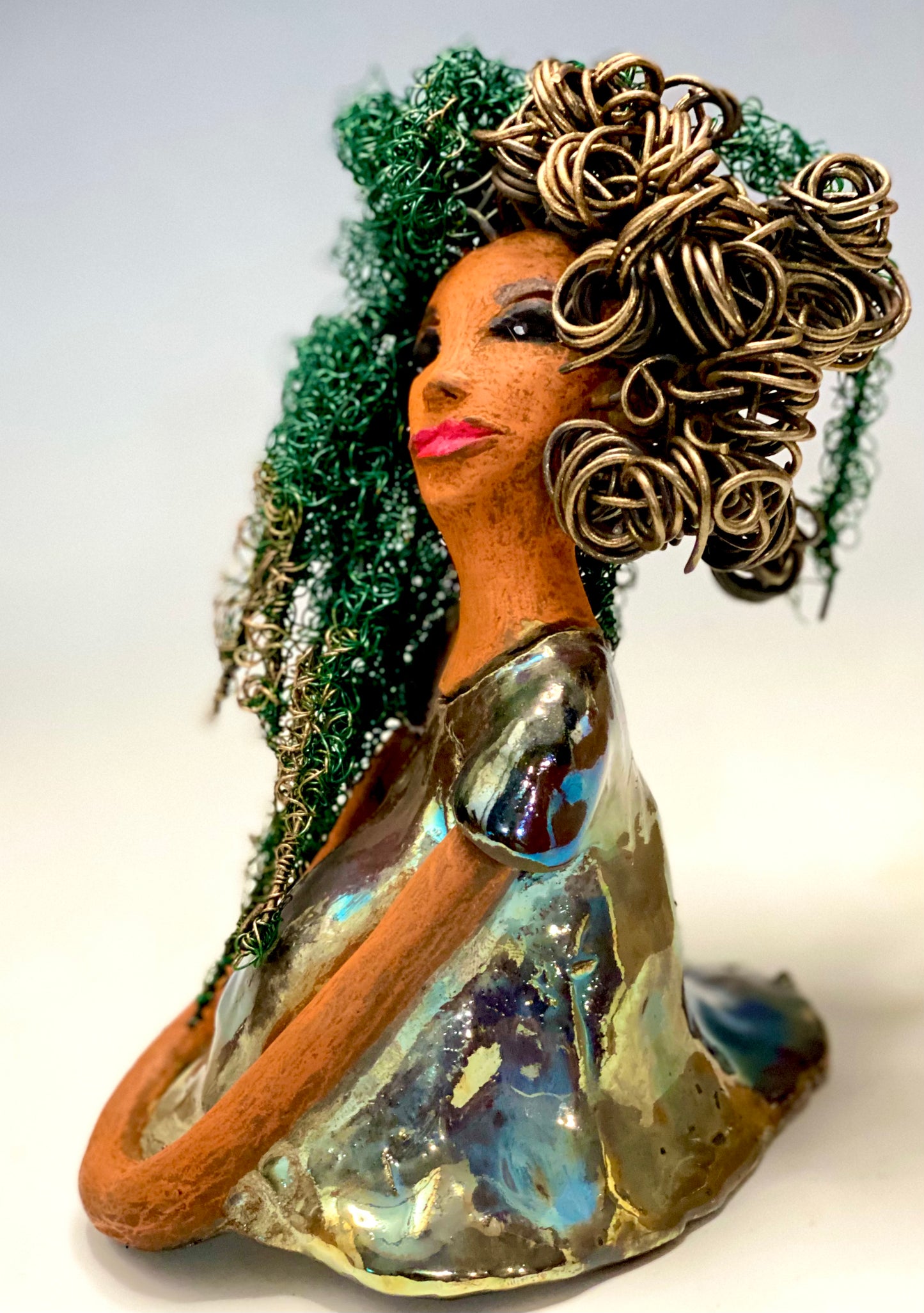 Diane stands 7" x 6" x 5.5" and weighs 1.9 lbs. She has a lovely honey brown complexion with reddish brown lips. She has long twisted wire locs hairstyle waist down! Diane has a very colorful metallic copper green antique glazed dress. She has over 75 feet of 16 and 24 gauge wire for hair. It took over 6 hours just to do her hair! With eyes wide opened, Diane has hope of finding a new home.