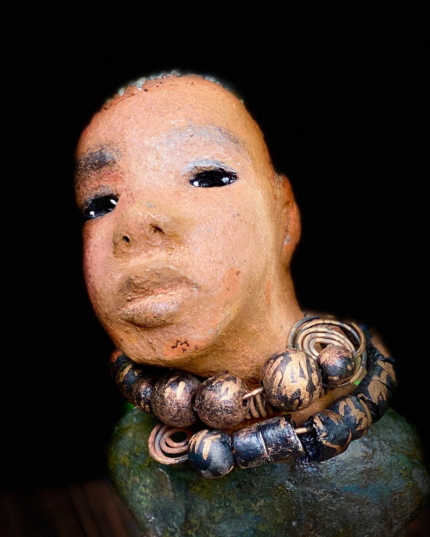 "It is obvious Herdew implies that most of my sculptures are female. My goal this year is to create ten male sculptures. Alvin is one of the first that I am pleased with. Alvin stands 9" x 4" x 4" and weighs 2.13 lbs. He wears a metallic multi colored jacket with metallic beads. Alvin has a dark honey brown complexion. Alvin seems to be in deep thought. Alvin would display proudly in your home.