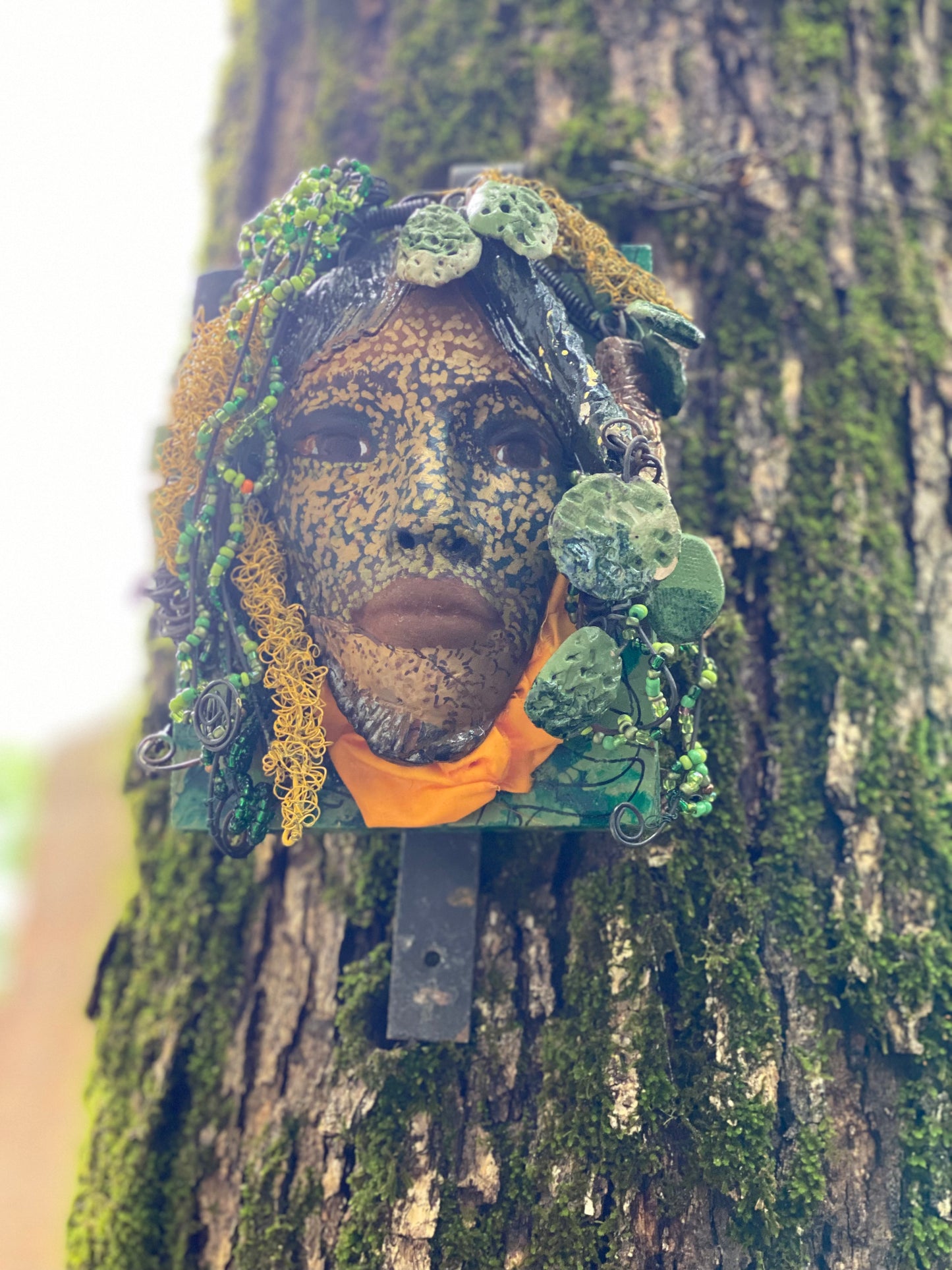 Casey is one of a new 2022 series of tribal masks that are mounted on wood. I started making art soon after seeing authentic African artwork at the Smithsonian Museum of African Art. I was in total awe. Casey is 6” x 7 x 1 and weighs 1.13 lbs. She has a contagious smile. Casey's face is speckled gold. 12 handmade raku fired beads Over 60 mini 6mm multi colored beads Over 60 feet of 16 and 24 gauge twisted wire for hair! Over two weeks to complete! Casey is ready to be mounted inside or outdoors!