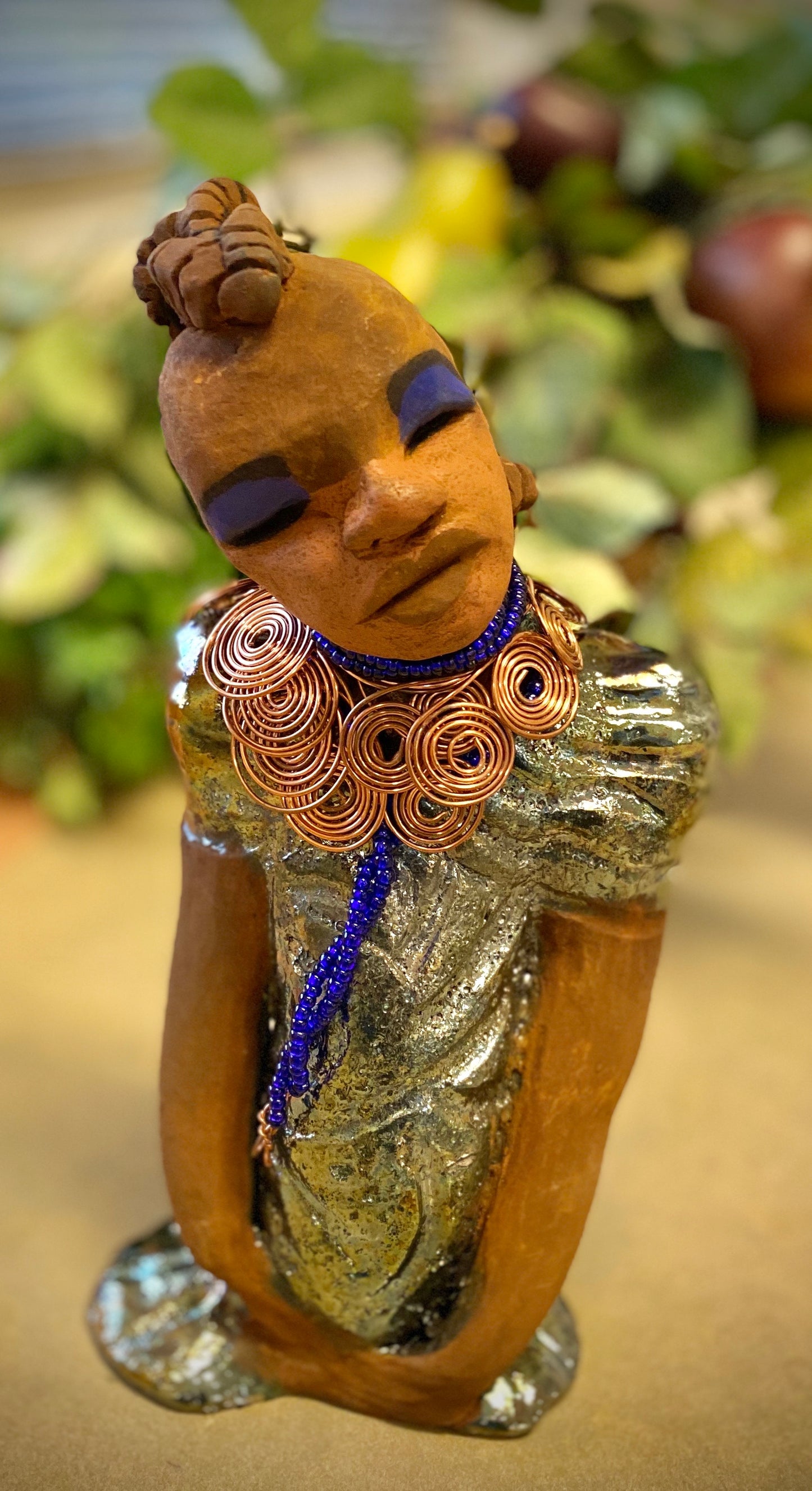 Georgia stands 11" x 5" x 3" and weighs 2.15 lbs. She has a honey brown complexion with a braided tribal clay hairstyle. She has an awesome copper metallic glitzy dress. Georgia has her long loving arms folded as she rest and waits. Give Georgia special place inside of your home.