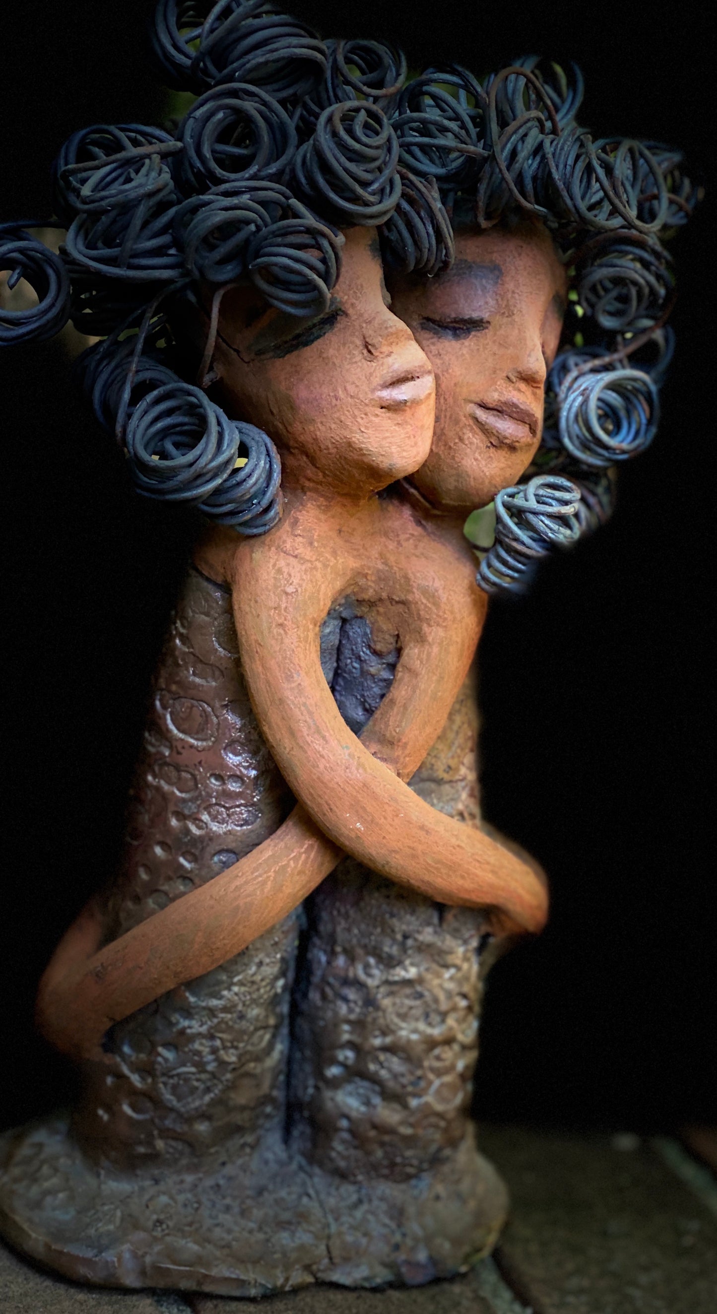 Sister Love is a raku fired sculpture. Raku is a specialized firing technique that involves high heat and open flames. Sister Love stands 11" x 5" x 3" and weighs 2.06 lbs. Combined they have over 45 feet of curled 16 gauge wire hair. The dresses are textured with an antique copper glaze. They have lovely honey brown complexions and long loving arms. Sister Love is inseparable! Give them a special place in your home. Free Shipping!