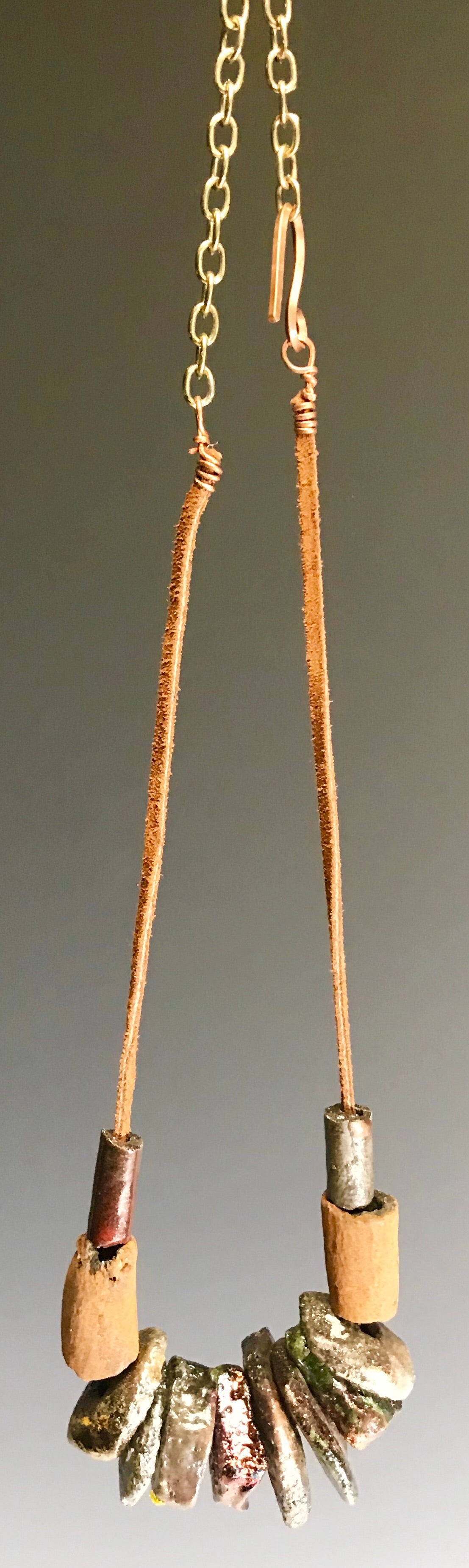 Simple and Beautiful!       10 metallic  disc , 2 matte beads.     20"  brown suede cord     Gold extension chain     Amazingly Lightweight! 3 ozs!!  Shipping and Returns