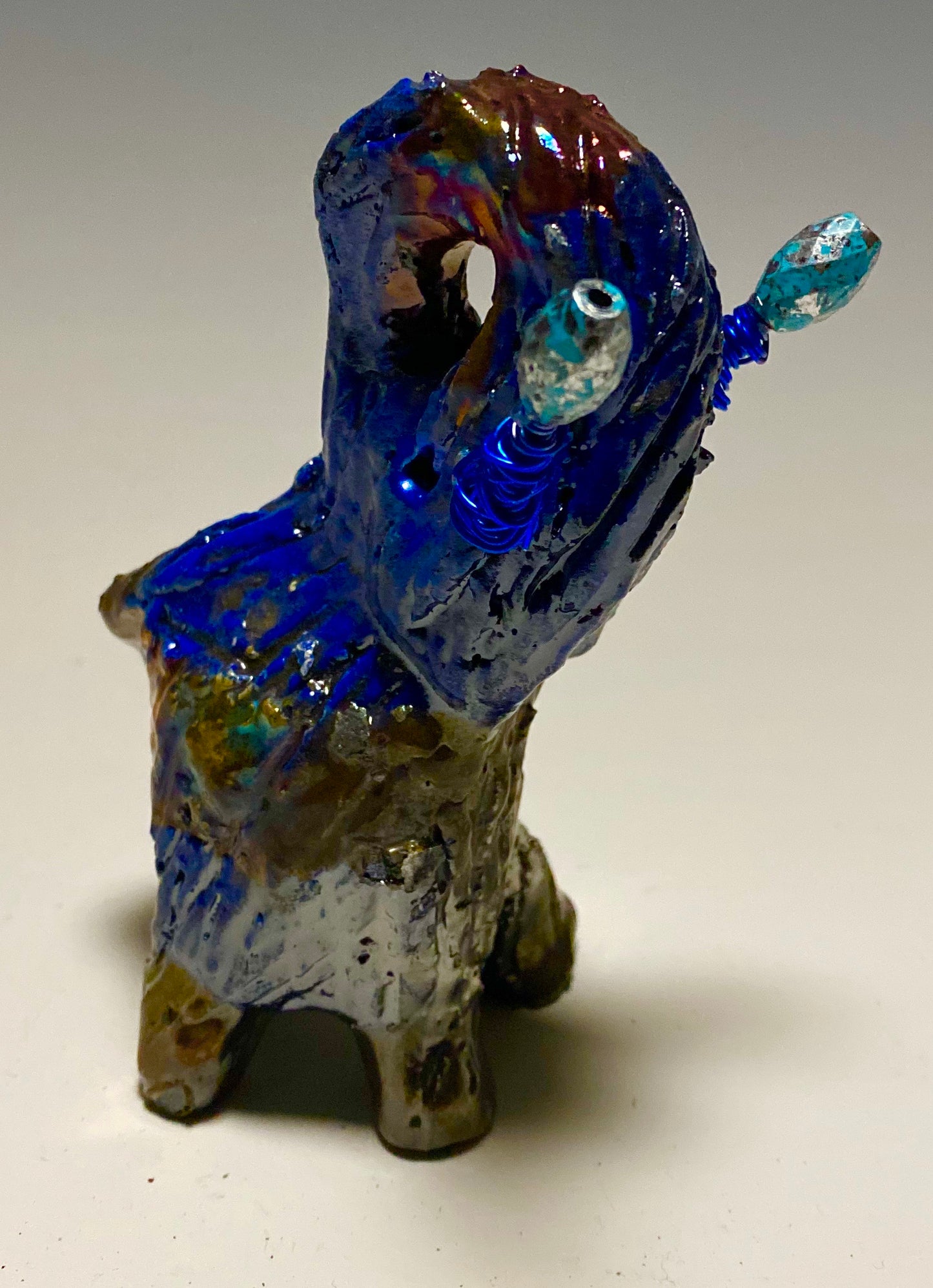 Raku Elephant Have you HERD!!!!!! Just one of these lovely Raku Fired Elephant will make an excellent gift for your friend, sorority or for your home’ special place centerpiece. 5" x 4" x 4" 9 ozs. Blue wire beaded blue tusk Beautiful metallic raku colors For decorative purposely only.