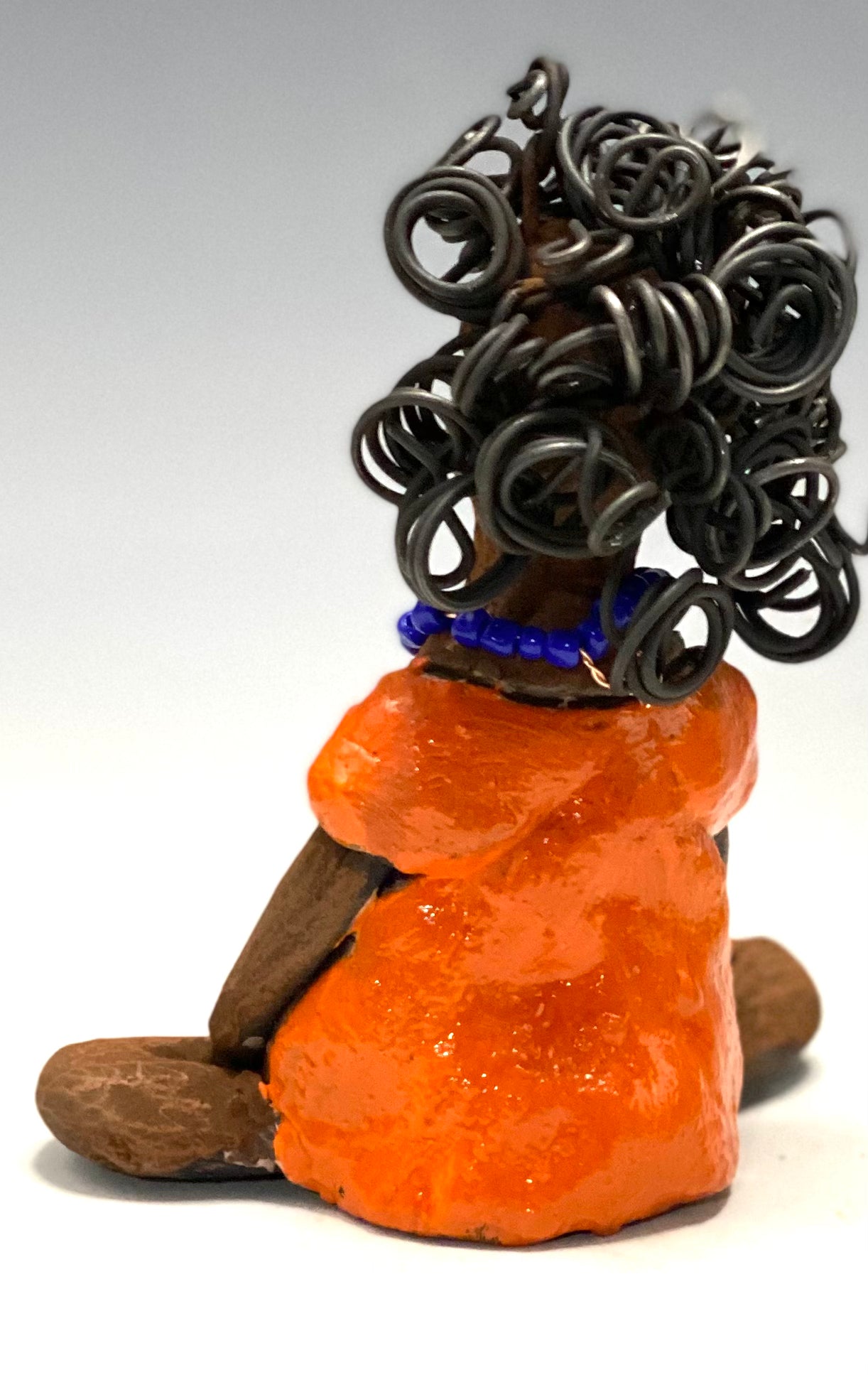 Asia stands 5" x 4" x 3.5" and weighs 8.75 ozs. She has a lovely honey brown complexion with cocoa brown lips. She has a really big curly hairstyle! Asia has beautiful a orange dress dress accented with a blue beaded necklace! . She has over 15 feet of 16 gauge wire for hair. It took over 2 hours just to do her hair! With eyes wide opened, Asia has hope of finding a new home.