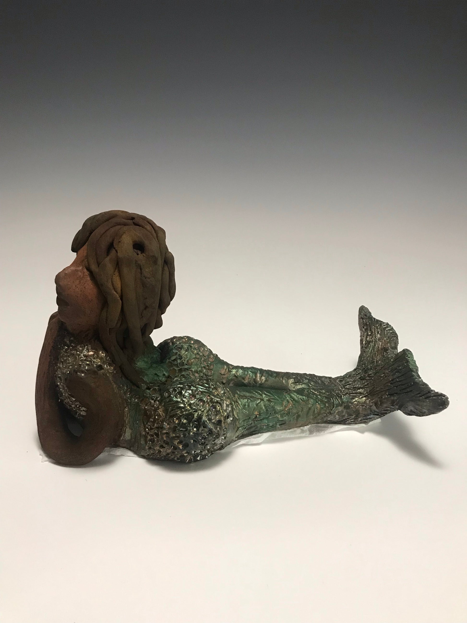 Meet Belinda!  Belinda is a voluptuous mermaid. She stands 6.5" X 5" 9.5" and weighs 2.04 lbs. Belinda has a dark chocolate complexion.      She wears a  dark smokey clay hairstyle.      She wears a glossy metallic swimsuit.     Belinda has a wide tail.     She will  definitely get somebody's attention.   Let Belinda get the conversation started at your home!